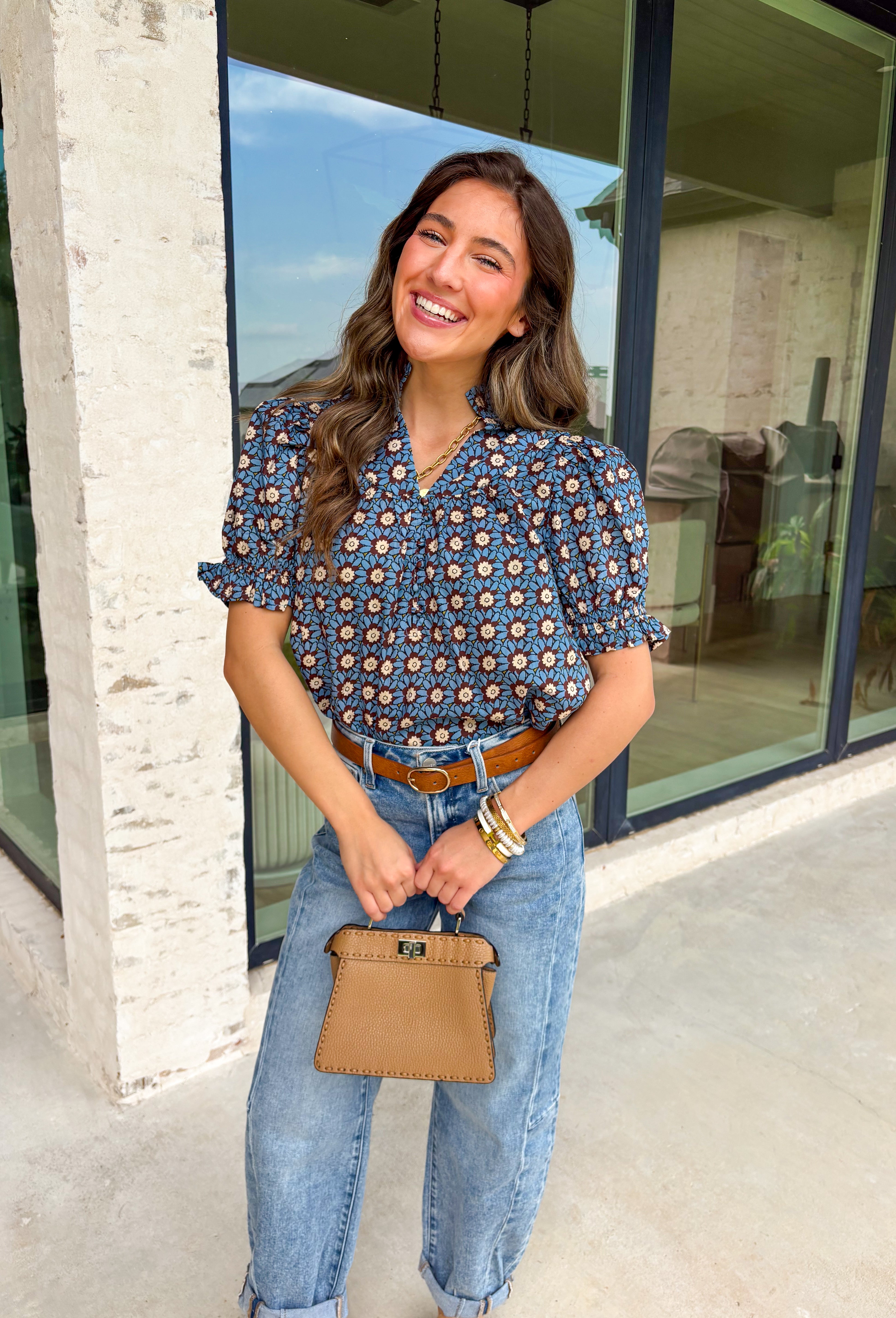 Fall florals have never looked so pretty! This ruffle edge puff sleeve top brings a cozy autumn vibe with its rich brown background and dreamy blue floral print. Whether you're heading to brunch or layering it under a jacket for a pumpkin patch moment, this one's an effortless favorite.
