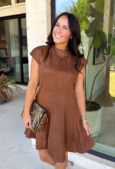 Holiday plans call for a dress that feels just as special as the occasion, and this brown faux suede dress from Fate is ready for every invite. The rich brown color and soft faux suede give it a warm seasonal look, while the structured paneled silhouette creates a flattering, defined shape. Vertical seaming through the bodice draws the eye to the fitted waist and hips before flowing into a flared A-line skirt. 