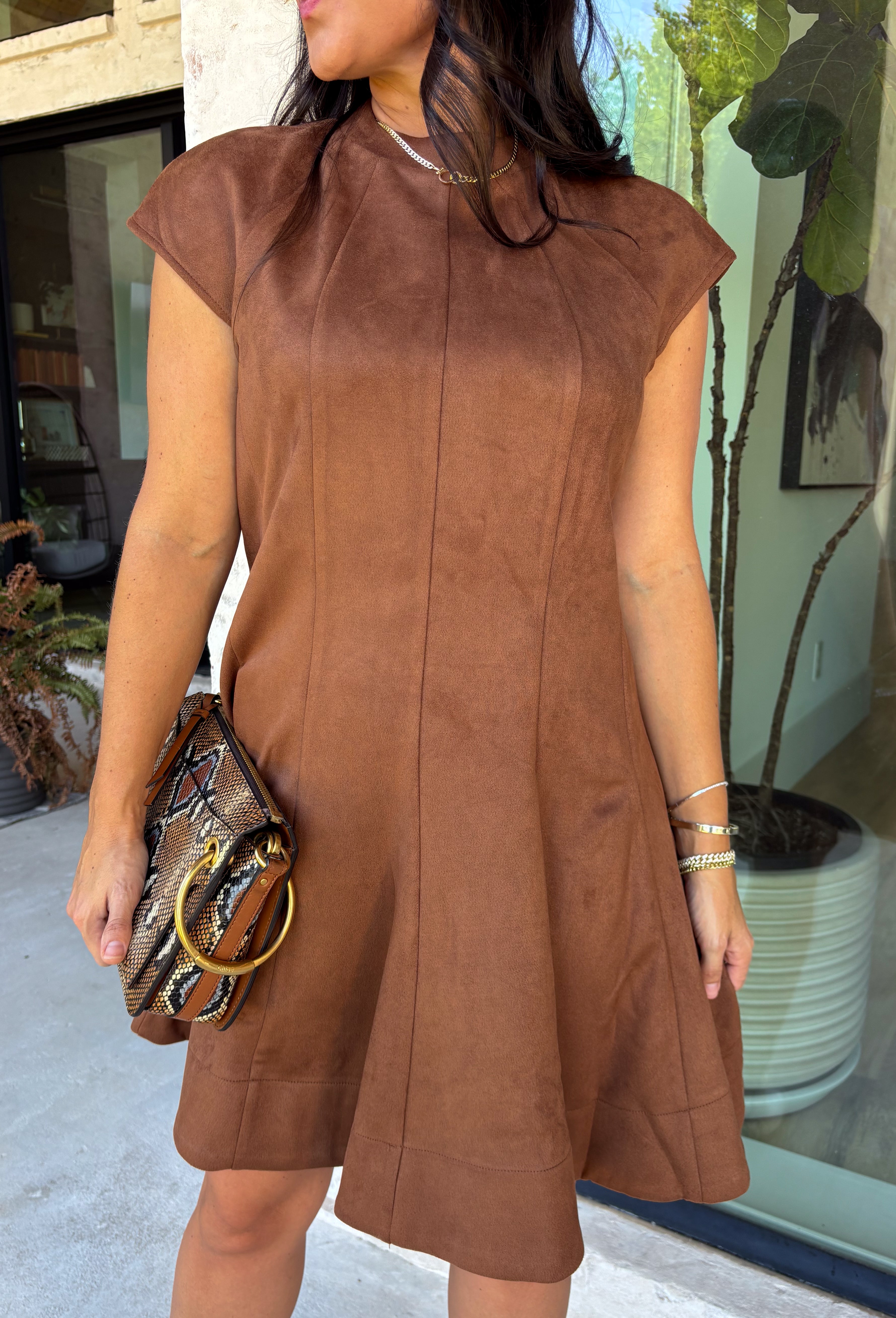 Holiday plans call for a dress that feels just as special as the occasion, and this brown faux suede dress from Fate is ready for every invite. The rich brown color and soft faux suede give it a warm seasonal look, while the structured paneled silhouette creates a flattering, defined shape. Vertical seaming through the bodice draws the eye to the fitted waist and hips before flowing into a flared A-line skirt. 