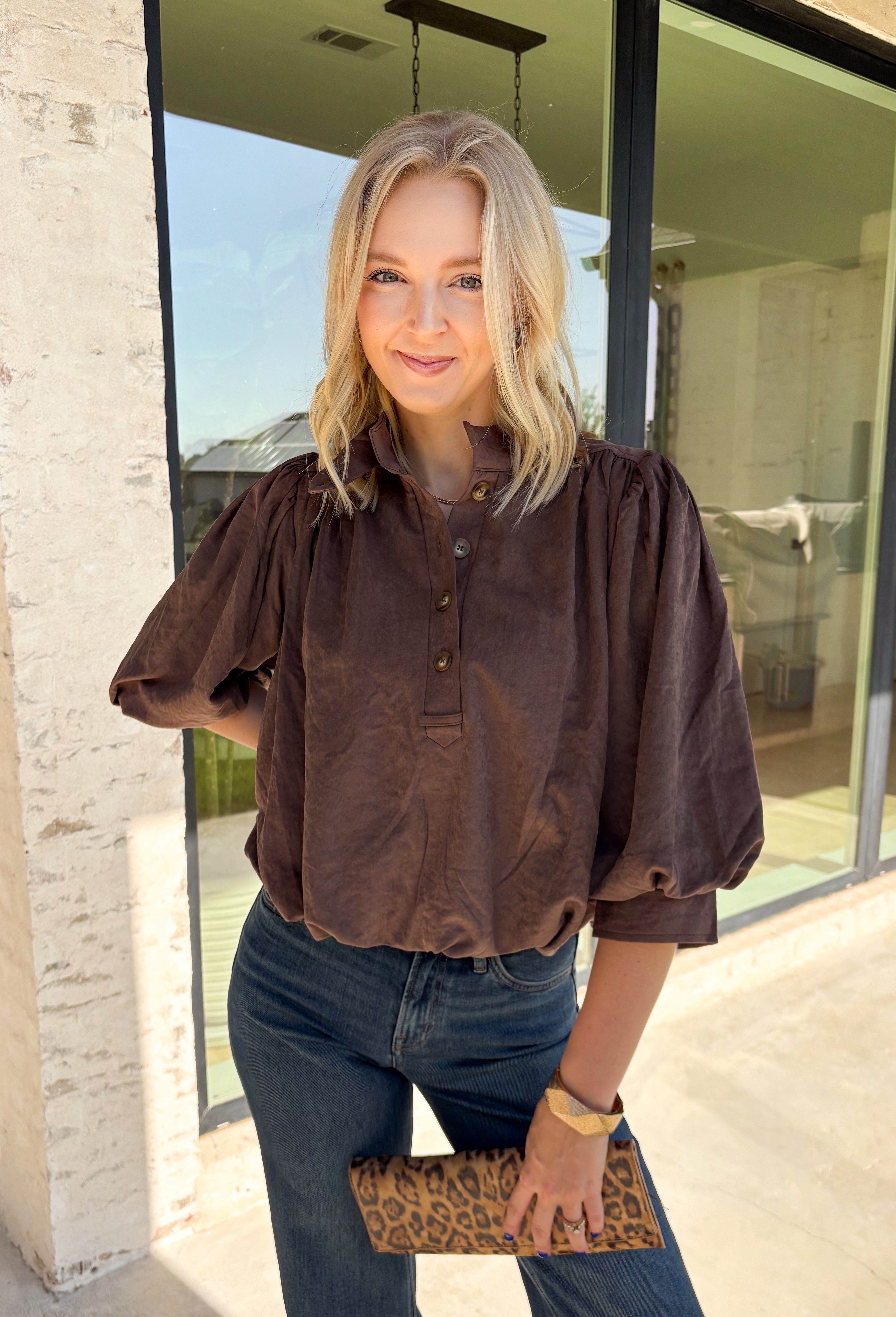 Meet the kind of top that makes getting dressed for the day feel easy. This solid top from Entro features a stand collar and partial button-front closure for a clean, classic look that works just as well at the office as it does for weekend plans. The ¾ balloon sleeves bring a little volume to the silhouette, while the elastic hem creates a flattering shape without needing to tuck it in. Lightweight and versatile, it’s an easy piece to pair with denim, trousers, or skirts throughout the fall season.