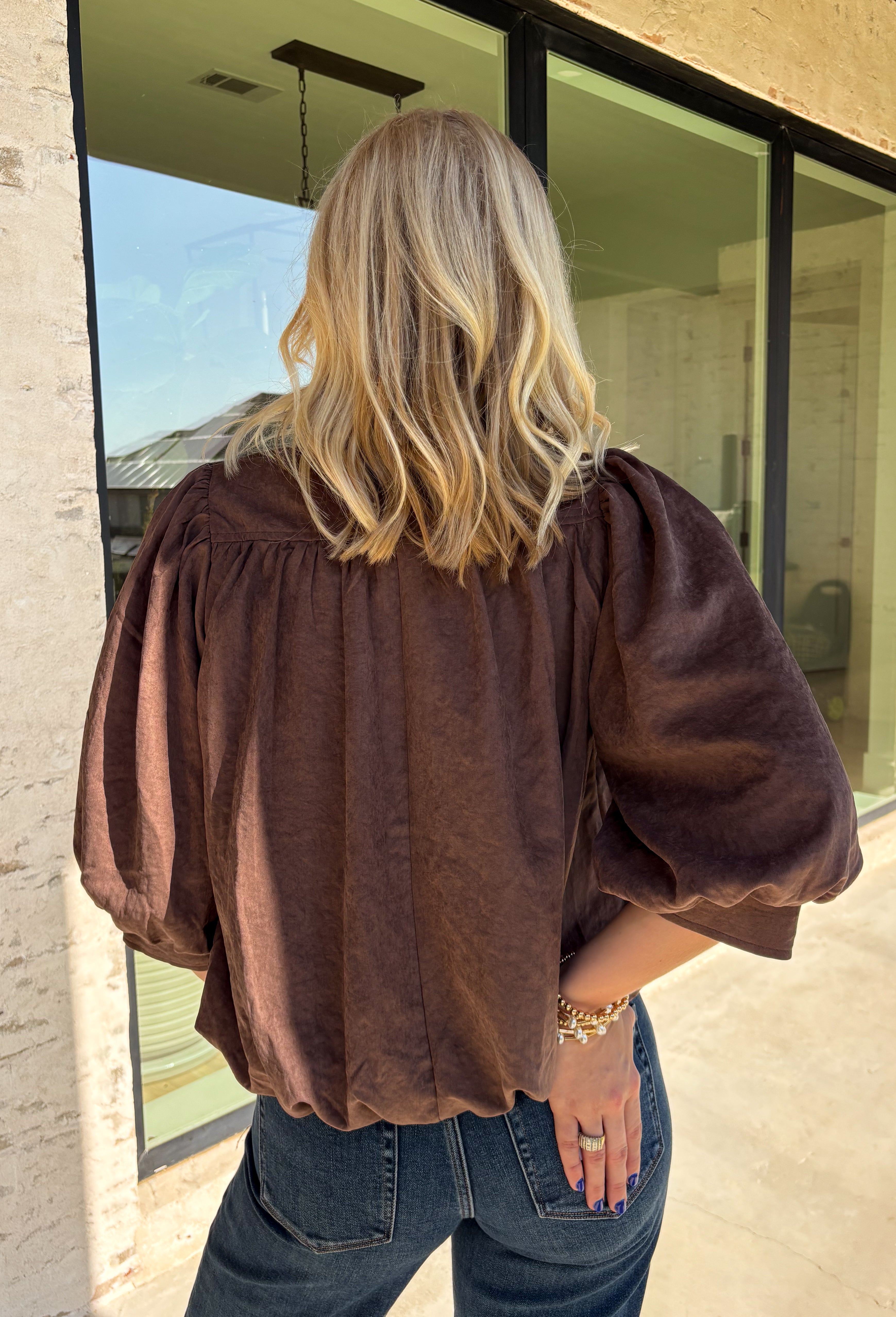 Meet the kind of top that makes getting dressed for the day feel easy. This solid top from Entro features a stand collar and partial button-front closure for a clean, classic look that works just as well at the office as it does for weekend plans. The ¾ balloon sleeves bring a little volume to the silhouette, while the elastic hem creates a flattering shape without needing to tuck it in. Lightweight and versatile, it’s an easy piece to pair with denim, trousers, or skirts throughout the fall season.
