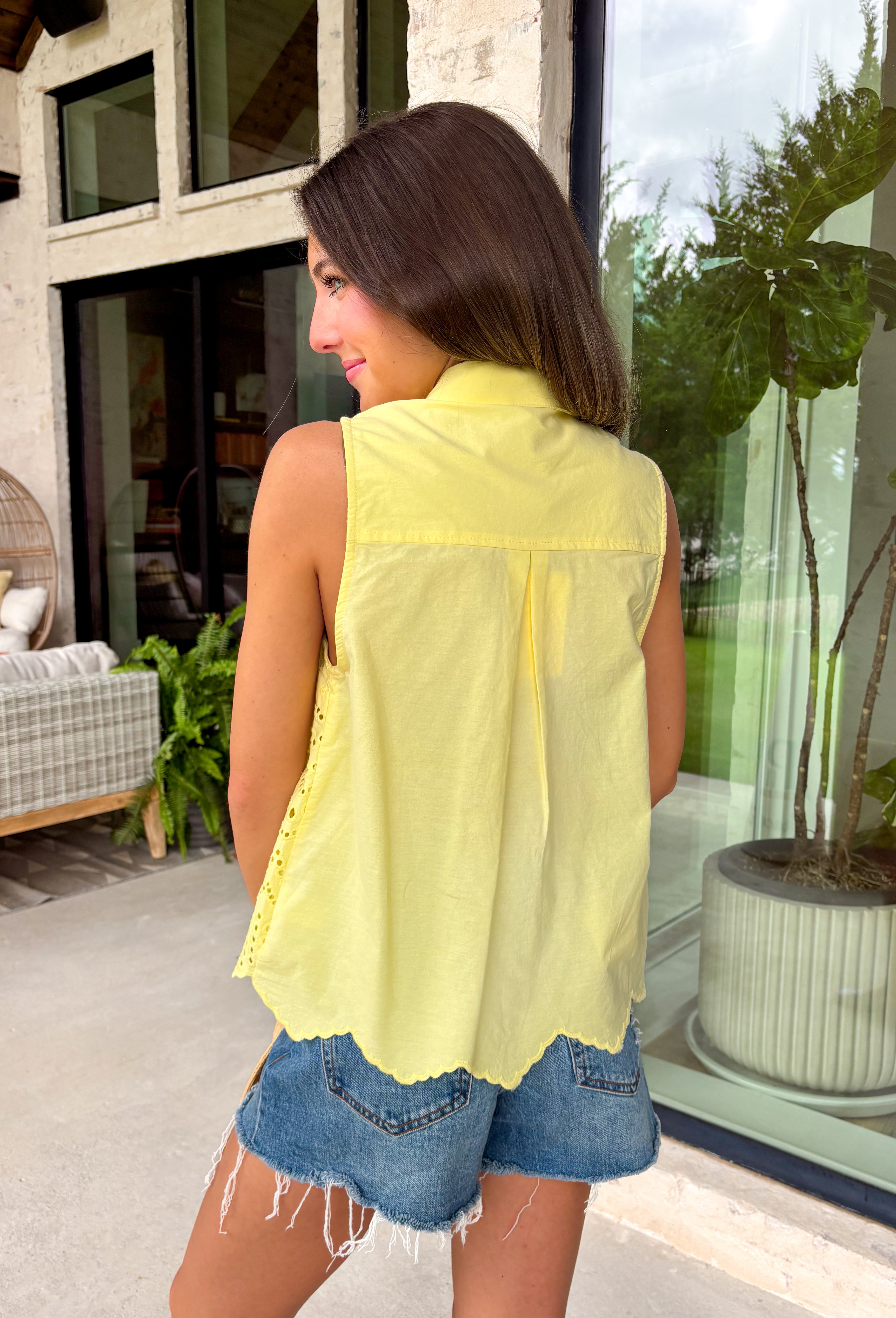 This lemon yellow sleeveless top is pure sunshine for your summer wardrobe! The bright, happy color instantly lifts your look, while the eyelet embroidery adds the prettiest touch of texture. The self-tie neckline brings a soft, feminine detail, and the scalloped hem gives it that extra something special. Designed with a button front and lightweight cotton fabric, it’s breathable and easy to wear all day long. Pair it with white denim or shorts for a fresh, standout outfit—this one is made for sunny days.