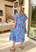This blue floral midi dress is giving major springtime charm with a fun pop of color! The pink floral print feels bright and cheerful, while the dark pink and turquoise trim along the front and sleeve cuffs adds the cutest contrast detail that makes this dress stand out in the best way. The tiered skirt brings that breezy, twirl-worthy movement we love, and with side pockets + a full lining, it’s just as practical as it is pretty. 