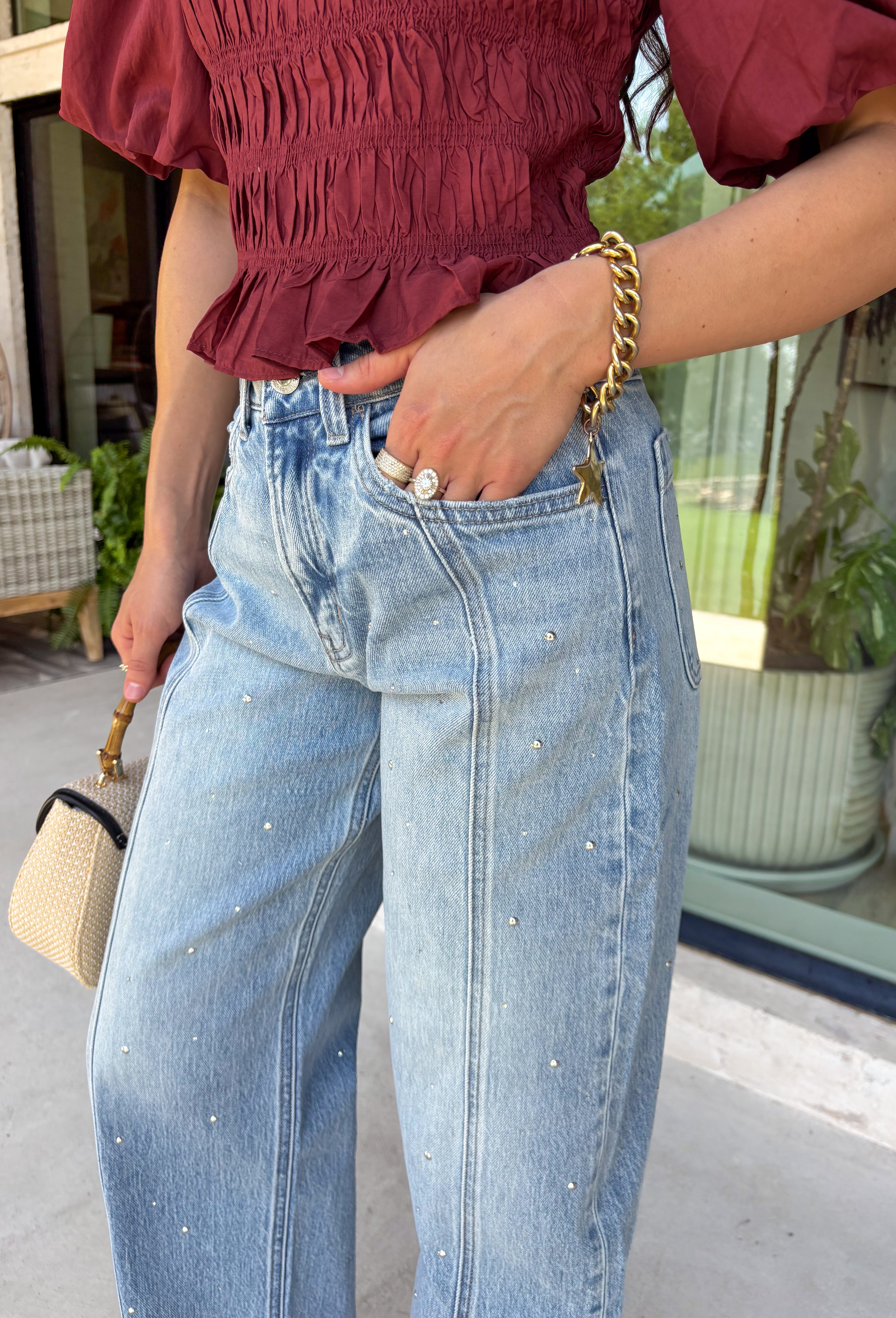 Everyone's favorite barrel jean just got a glamorous upgrade! These high-rise light wash barrel jeans feature crystal and embellishment details throughout, giving a trendy silhouette an eye-catching twist. The flattering high-rise fit helps create a streamlined shape, while the relaxed barrel leg keeps them comfortable and on-trend. Perfect for date nights, concerts, weekend outings, or simply elevating your everyday style, these jeans effortlessly blend casual and chic.