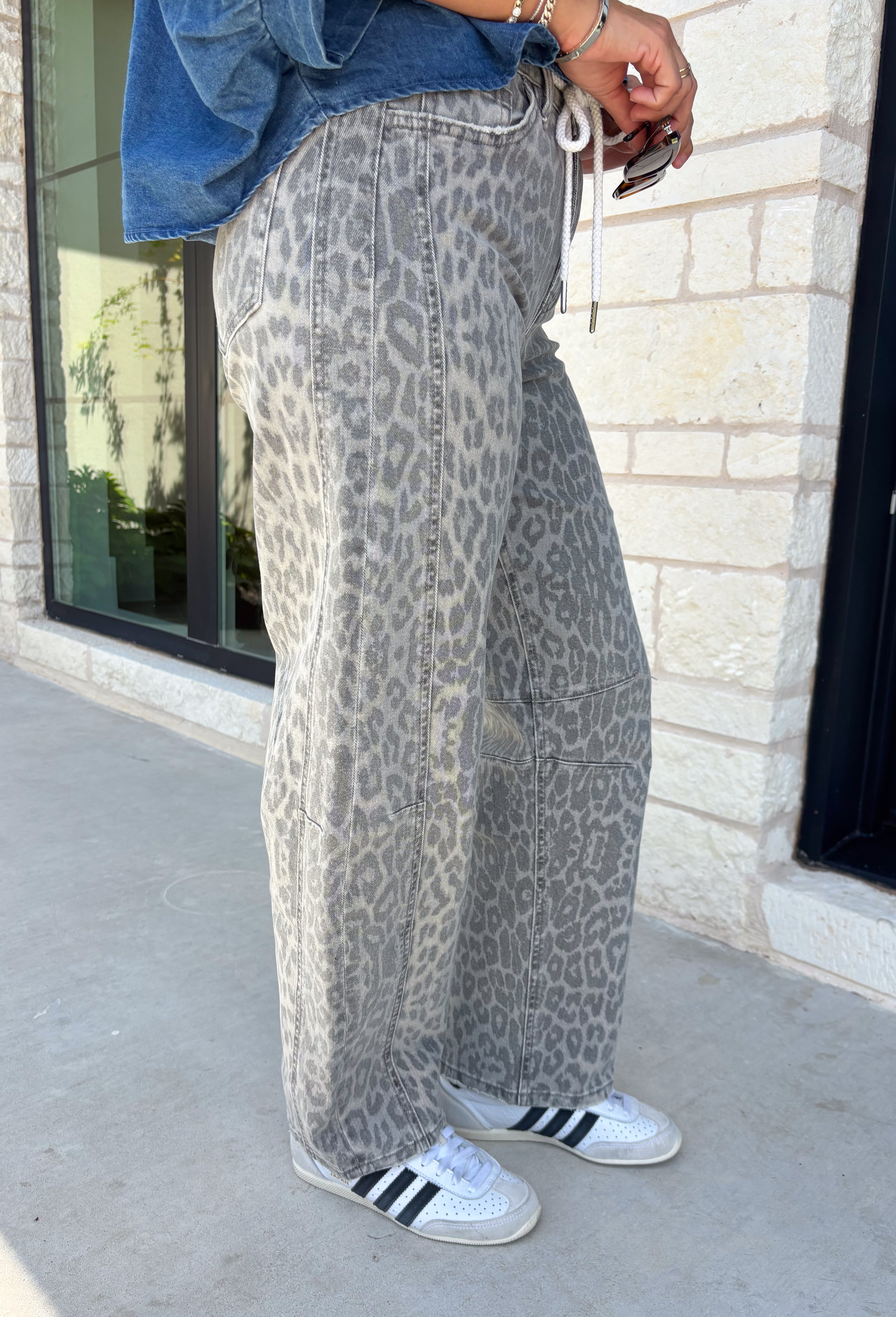 Everyone’s favorite barrel jean is back in a fun new print! These high waisted gray leopard print jeans are the perfect way to add a little personality to your everyday wardrobe while still keeping things neutral and easy to style. The barrel leg silhouette gives them that trendy, relaxed look everyone loves, while the drawstring detail adds an extra touch of comfort and casual charm. The gray-toned leopard print feels fresh and versatile, making these jeans easy to pair with everything.