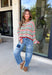 Cozy season gets a colorful update with this cream open knit sweater from Hyfve. The neutral cream base is woven with playful pops of red, blue, green, and black, giving it plenty of personality while still keeping it easy to mix and match. The open knit design creates a textured look that’s perfect for layering as those crisp fall days start turning colder. 