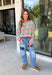 Cozy season gets a colorful update with this cream open knit sweater from Hyfve. The neutral cream base is woven with playful pops of red, blue, green, and black, giving it plenty of personality while still keeping it easy to mix and match. The open knit design creates a textured look that’s perfect for layering as those crisp fall days start turning colder. 