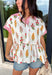 This white babydoll top is the perfect mix of playful and feminine for summer! The colorful floral print in yellow, red, and green brings a bright, happy feel, while the red and white stripe detail on the collar and sleeves adds the cutest pop of contrast. The babydoll silhouette keeps it light, breezy, and easy to wear, and the front button details give it that extra touch of charm. Made from breathable cotton, it’s perfect for warm days when you want something effortless but still fun.