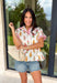 This white babydoll top is the perfect mix of playful and feminine for summer! The colorful floral print in yellow, red, and green brings a bright, happy feel, while the red and white stripe detail on the collar and sleeves adds the cutest pop of contrast. The babydoll silhouette keeps it light, breezy, and easy to wear, and the front button details give it that extra touch of charm. Made from breathable cotton, it’s perfect for warm days when you want something effortless but still fun.