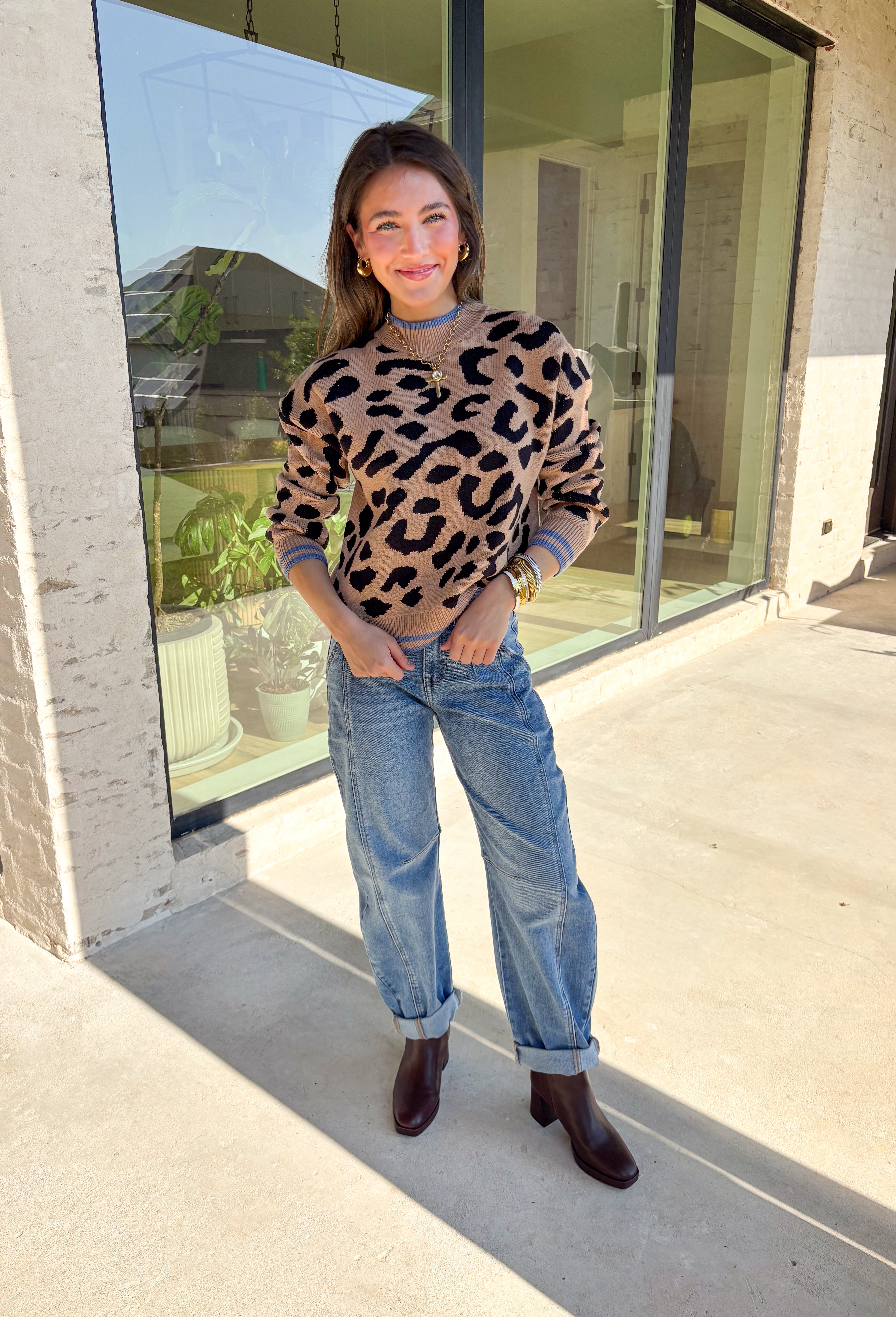 A cozy classic with a playful twist, this tan mock neck sweater is accented with a bold black leopard print. The pop of blue trim along the neckline, hem, and cuffs brings a modern contrast that sets it apart. Soft and stretchy in a comfy knit blend, it’s perfect for layering with denim, skirts, or trousers. A versatile piece that makes everyday outfits feel just a little more fun this fall.