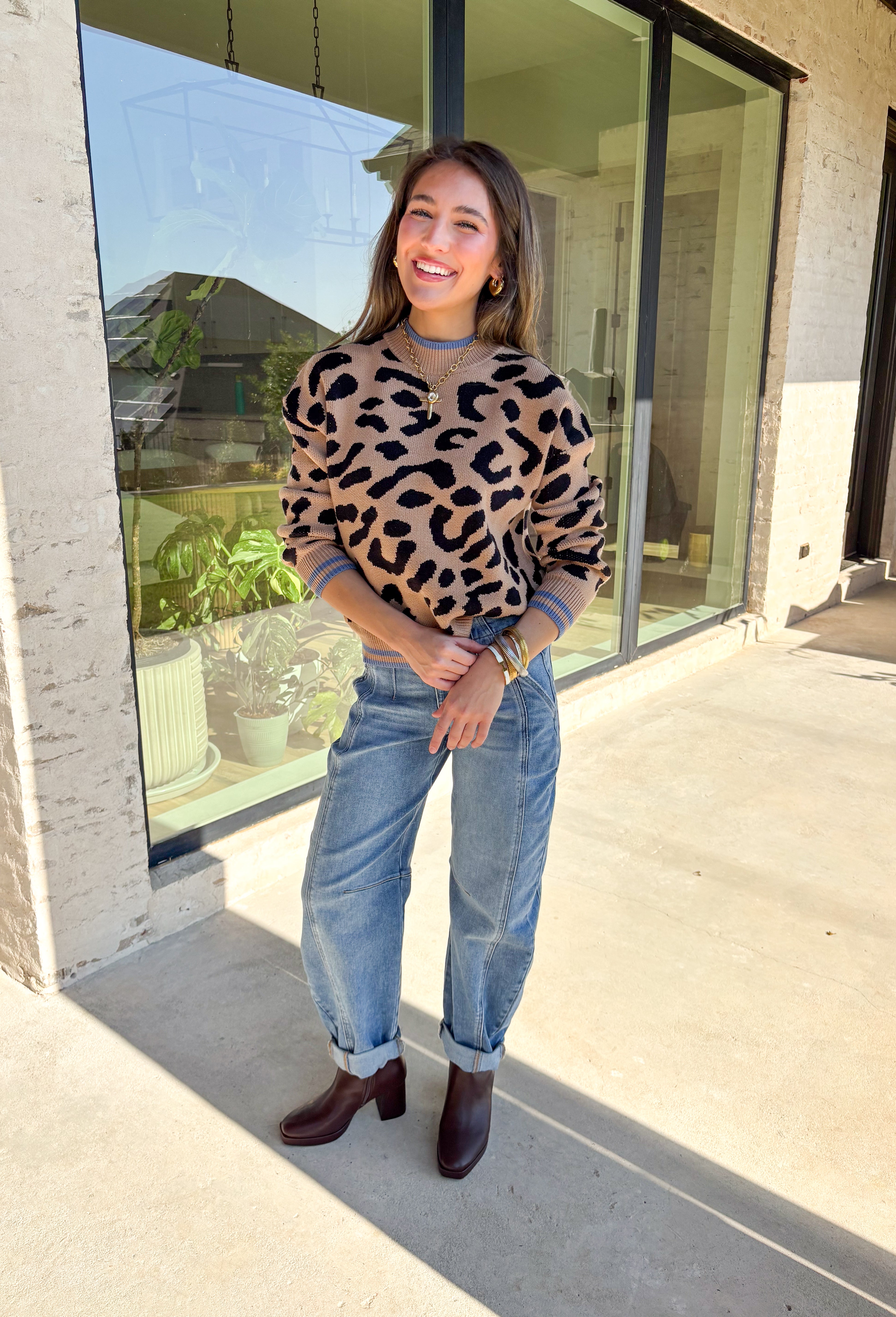 A cozy classic with a playful twist, this tan mock neck sweater is accented with a bold black leopard print. The pop of blue trim along the neckline, hem, and cuffs brings a modern contrast that sets it apart. Soft and stretchy in a comfy knit blend, it’s perfect for layering with denim, skirts, or trousers. A versatile piece that makes everyday outfits feel just a little more fun this fall.