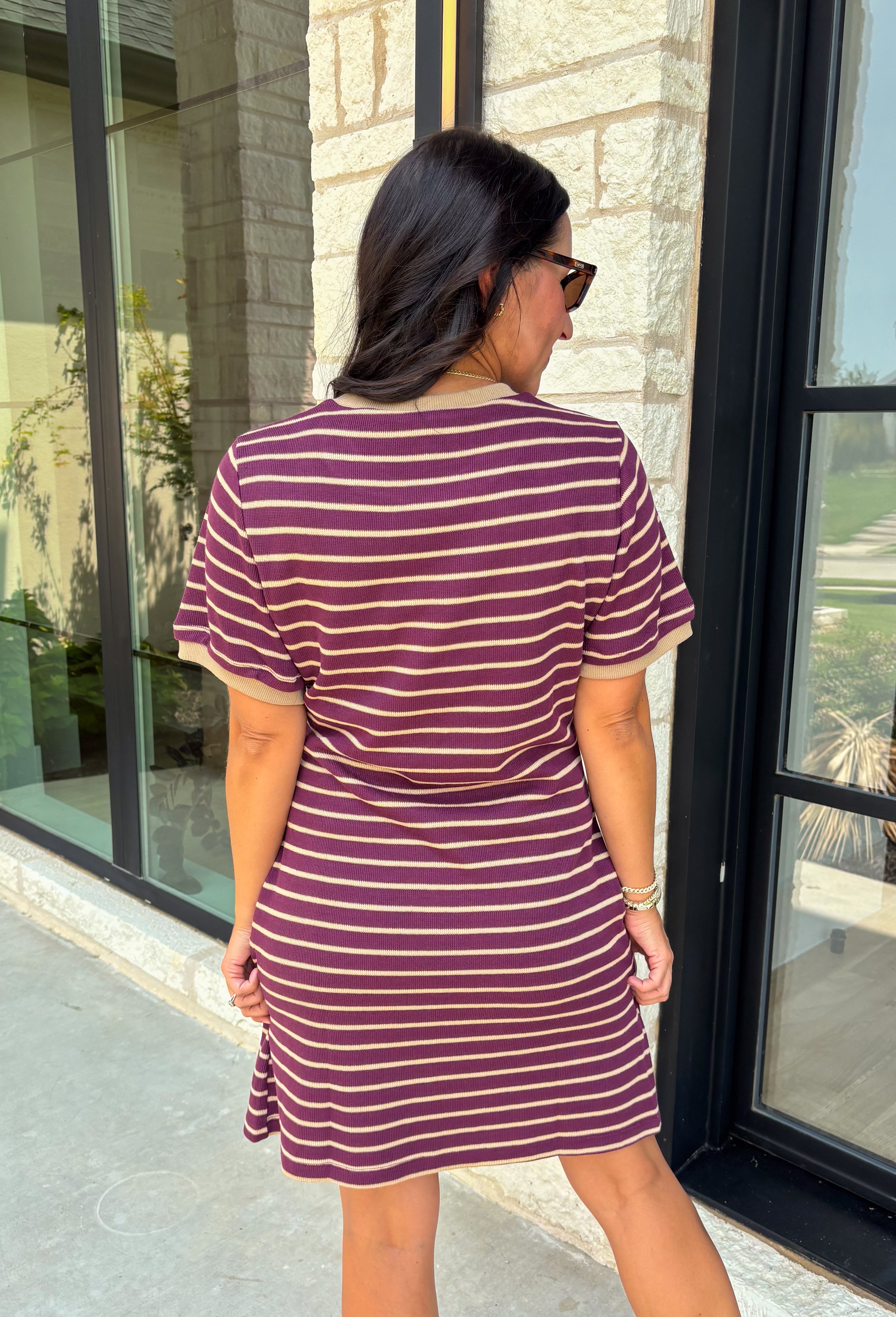 From busy weekdays to weekend plans, this striped dress is the effortless piece you'll find yourself reaching for again and again! Designed with classic plum and tan stripes, this lightweight dress offers the perfect mix of comfort and polished style for the season. The adjustable self-tie waist creates a flattering silhouette, while the contrast ribbed neckline and sleeve cuffs add a sporty-chic touch that makes this dress stand out. 