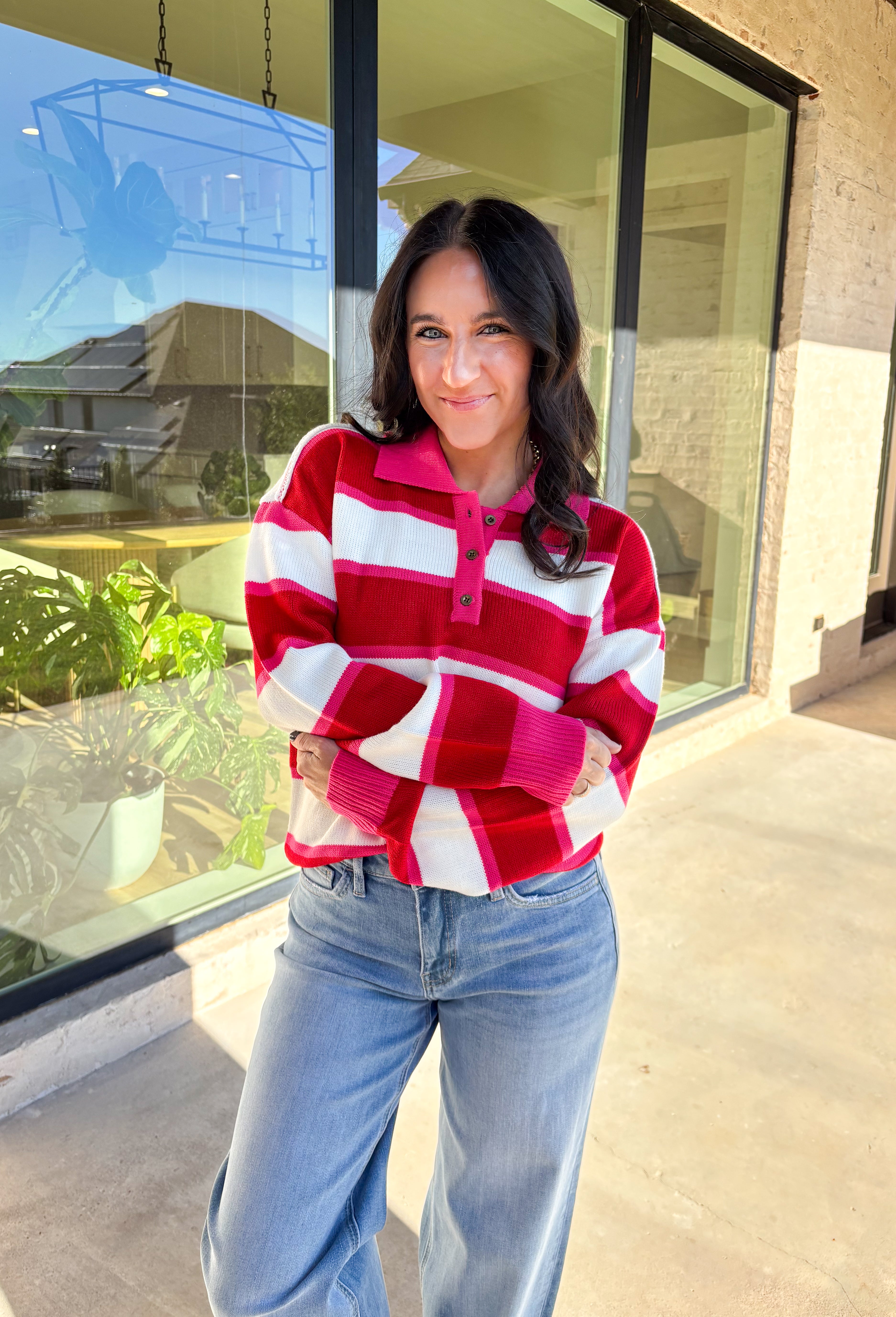 This striped sweater is giving retro prep meets pumpkin spice—and we’re here for it. With bold red, playful pink, and classic white stripes, it brings a cheerful twist to gloomy fall days. The collared neckline and front button details add a polished touch that feels just right for layering over your favorite jeans or corduroy skirt. Made from soft, cozy acrylic, it’s a lightweight piece that still keeps you warm on crisp autumn mornings. Whether you’re headed to the office or a cider-sipping weekend, this 