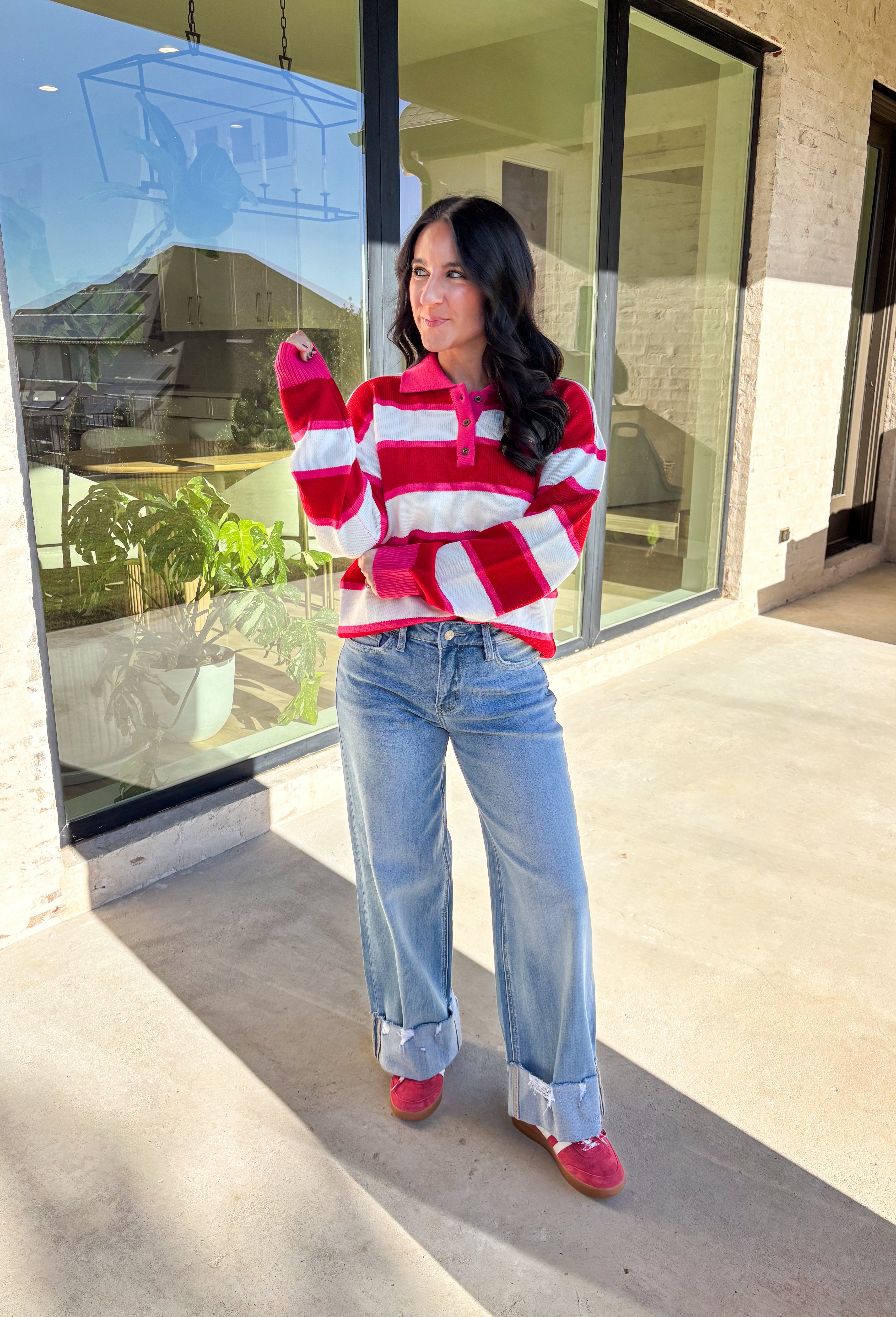 This striped sweater is giving retro prep meets pumpkin spice—and we’re here for it. With bold red, playful pink, and classic white stripes, it brings a cheerful twist to gloomy fall days. The collared neckline and front button details add a polished touch that feels just right for layering over your favorite jeans or corduroy skirt. Made from soft, cozy acrylic, it’s a lightweight piece that still keeps you warm on crisp autumn mornings. Whether you’re headed to the office or a cider-sipping weekend, this 