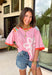 This pink floral top is full of those pretty little details that make summer outfits feel extra special! Featuring a colorful floral print with embroidered accents and white eyelet detailing, it has the perfect mix of texture and charm. The coral trim along the neckline and sleeves adds a fun pop of contrast that really makes it stand out. Lightweight and breathable in 100% cotton, it’s perfect for warm days when you want something easy but still eye-catching. 