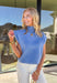 Soft, cozy, and perfect for spring layering, this blue short sleeve sweater by Entro is an easy wardrobe favorite. Designed with a mock neck and ribbed knit texture, it has a clean, polished look that still feels relaxed and comfortable. Subtle open knit detailing along the front adds just the right amount of texture and interest, making it a simple piece that doesn’t feel basic. Lightweight and easy to style, it’s perfect for transitioning into warmer days.