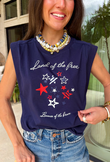 This navy graphic tank is made for celebrating summer and everything that comes with it! Featuring “Land Of The Free Because Of The Brave” with red, white, and blue star details, it brings the perfect patriotic touch for the 4th of July and beyond. The mix of printed and embroidered elements adds dimension and makes it feel extra special. Lightweight and breathable in 100% cotton, it’s perfect for warm days filled with BBQs, fireworks, and time with friends and family. 