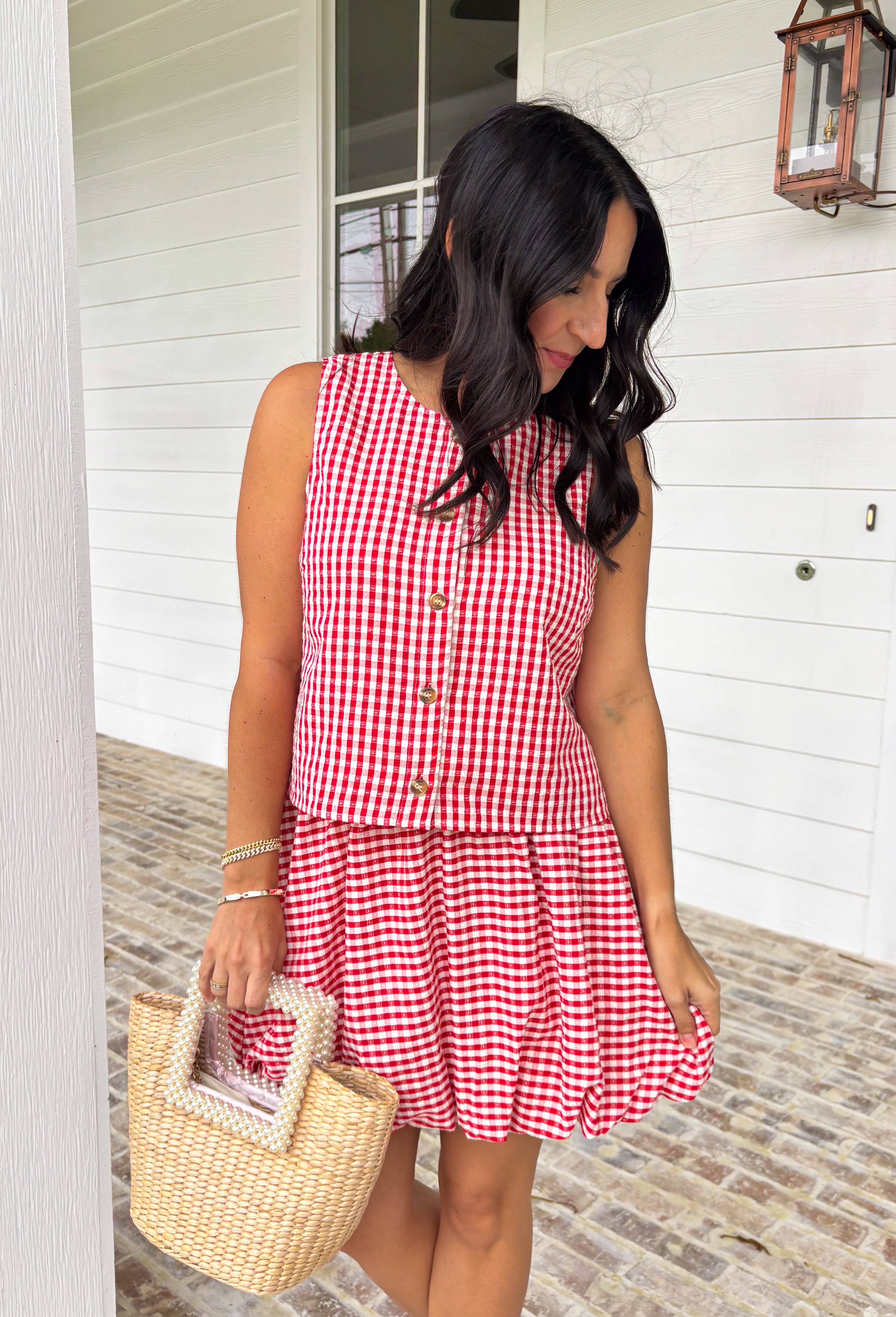 Nothing says sunny days and sweet summertime like a classic red and white gingham print. This sleeveless button down top is equal parts timeless and playful, making it a go-to for backyard barbecues, lake weekends, and especially the 4th of July. The crisp gingham pattern gives it that all-American charm, while the lightweight feel keeps it easy and comfortable all day long. Wear it with the matching skirt for an effortlessly coordinated set.