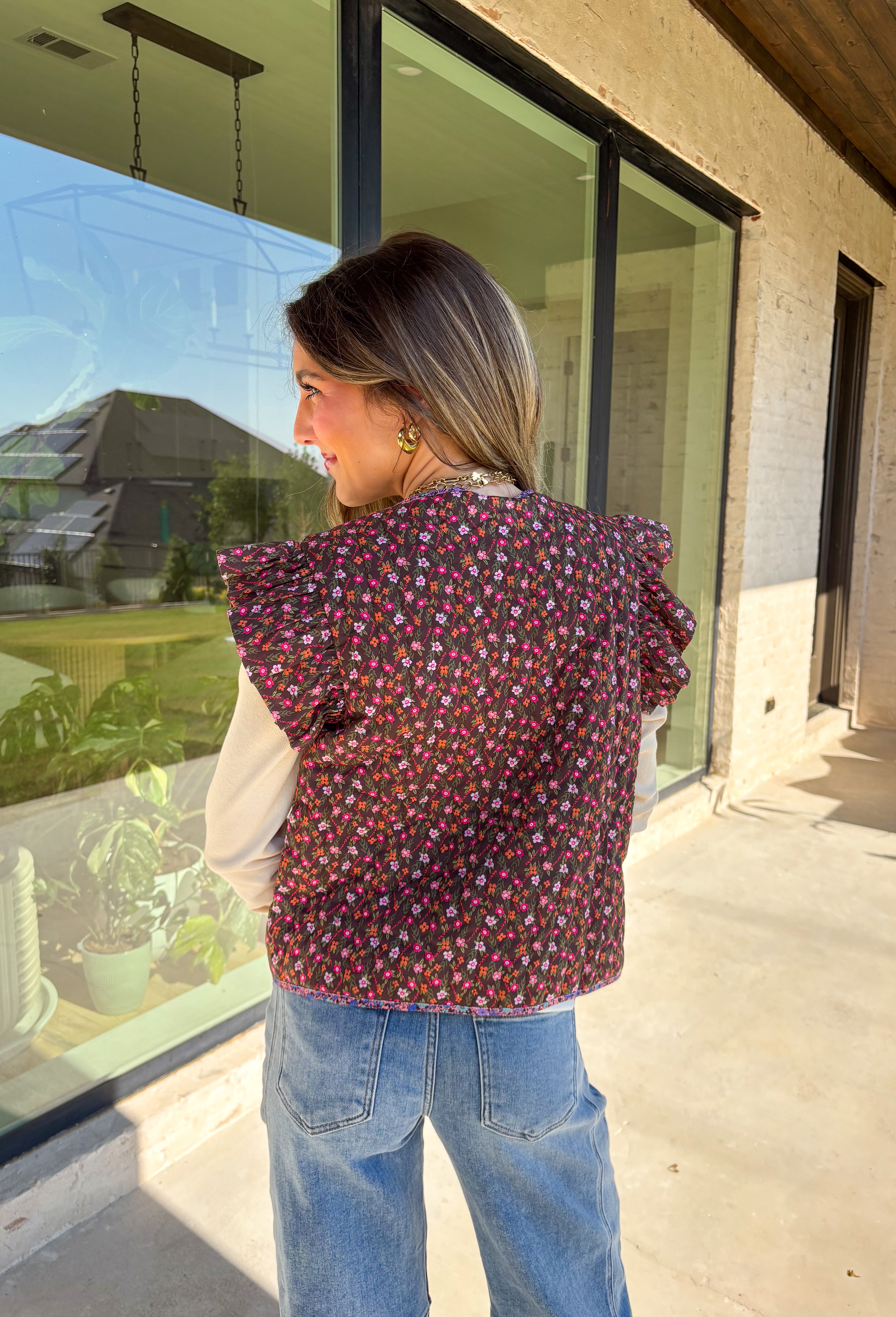 This charming quilted vest is giving all the cozy fall vibes with a pop of cheerful color. The brown base is covered in a dainty floral print in soft shades of pink, orange, and green—perfect for layering over your favorite long sleeve tops. Ruffle sleeves and oversized button closures add just the right amount of whimsy!