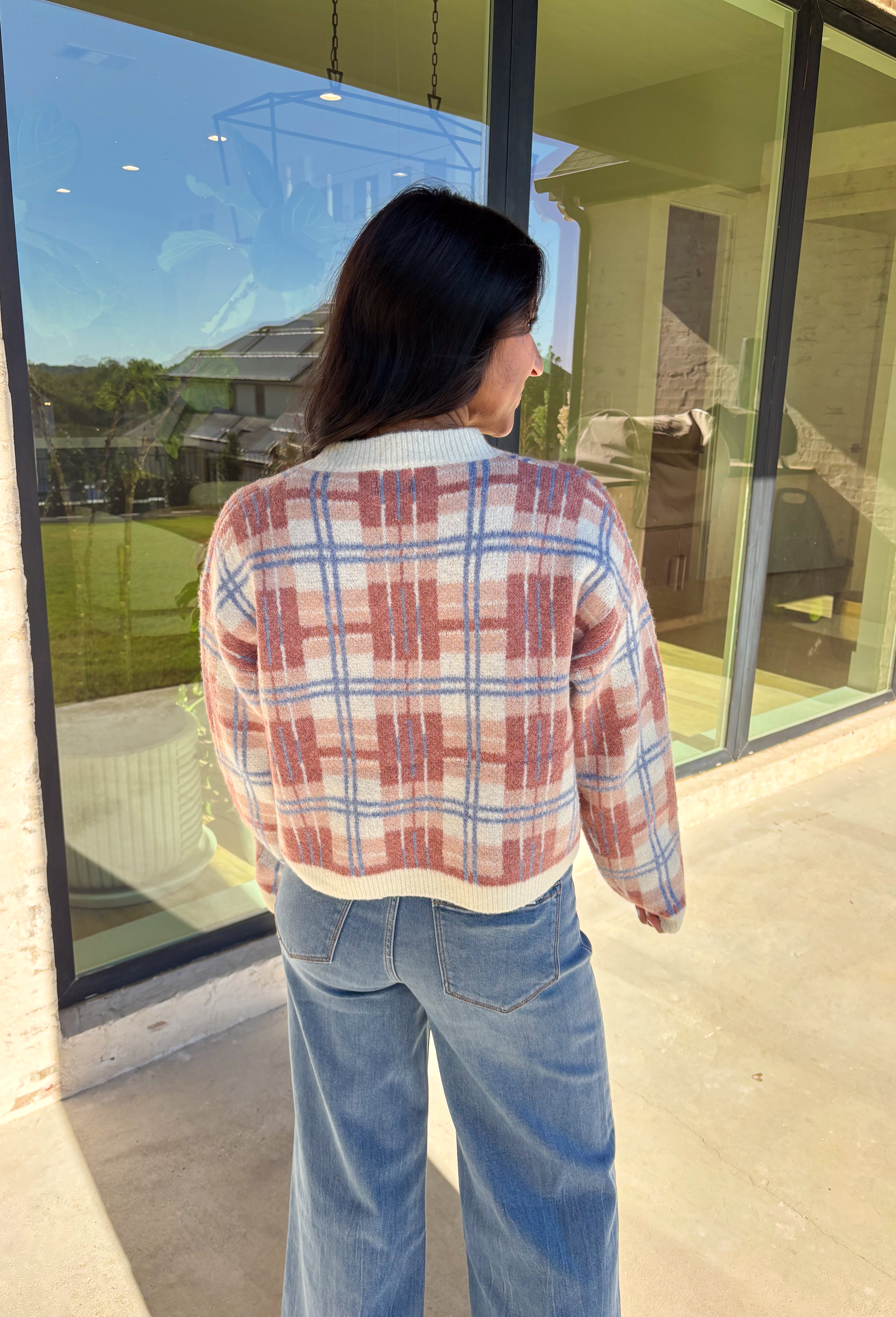 Plaid meets cozy charm in this cropped button-down cardigan. Designed in cream, blue, dark pink, and light pink, it’s the perfect pop of color for cooler days. Gold textured buttons add a polished detail, while the soft knit blend makes it extra comfortable. With its cropped fit and long sleeves, this cardigan is easy to style layered over a cami, tee, or even a dress for that just-right fall look.