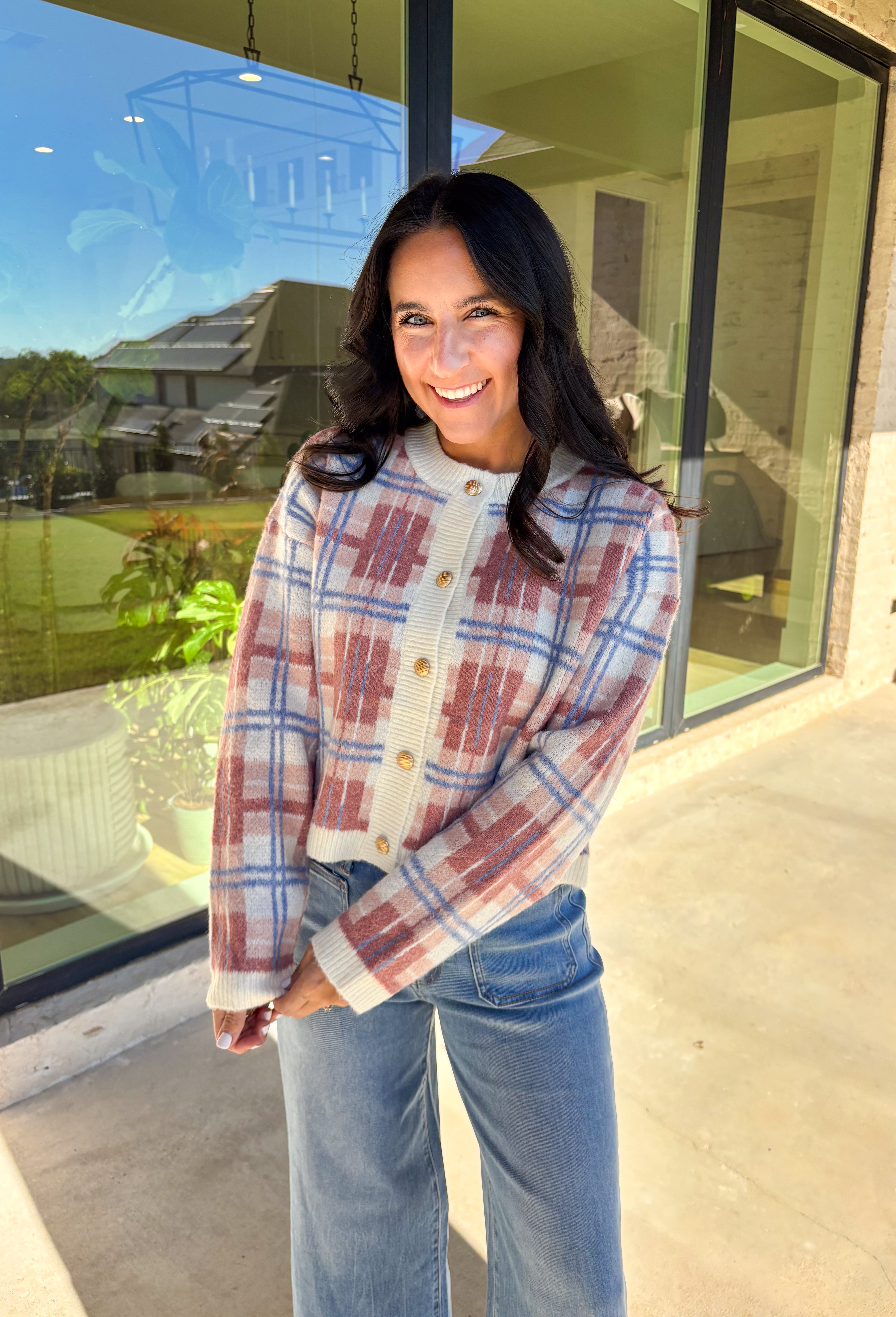 Plaid meets cozy charm in this cropped button-down cardigan. Designed in cream, blue, dark pink, and light pink, it’s the perfect pop of color for cooler days. Gold textured buttons add a polished detail, while the soft knit blend makes it extra comfortable. With its cropped fit and long sleeves, this cardigan is easy to style layered over a cami, tee, or even a dress for that just-right fall look.