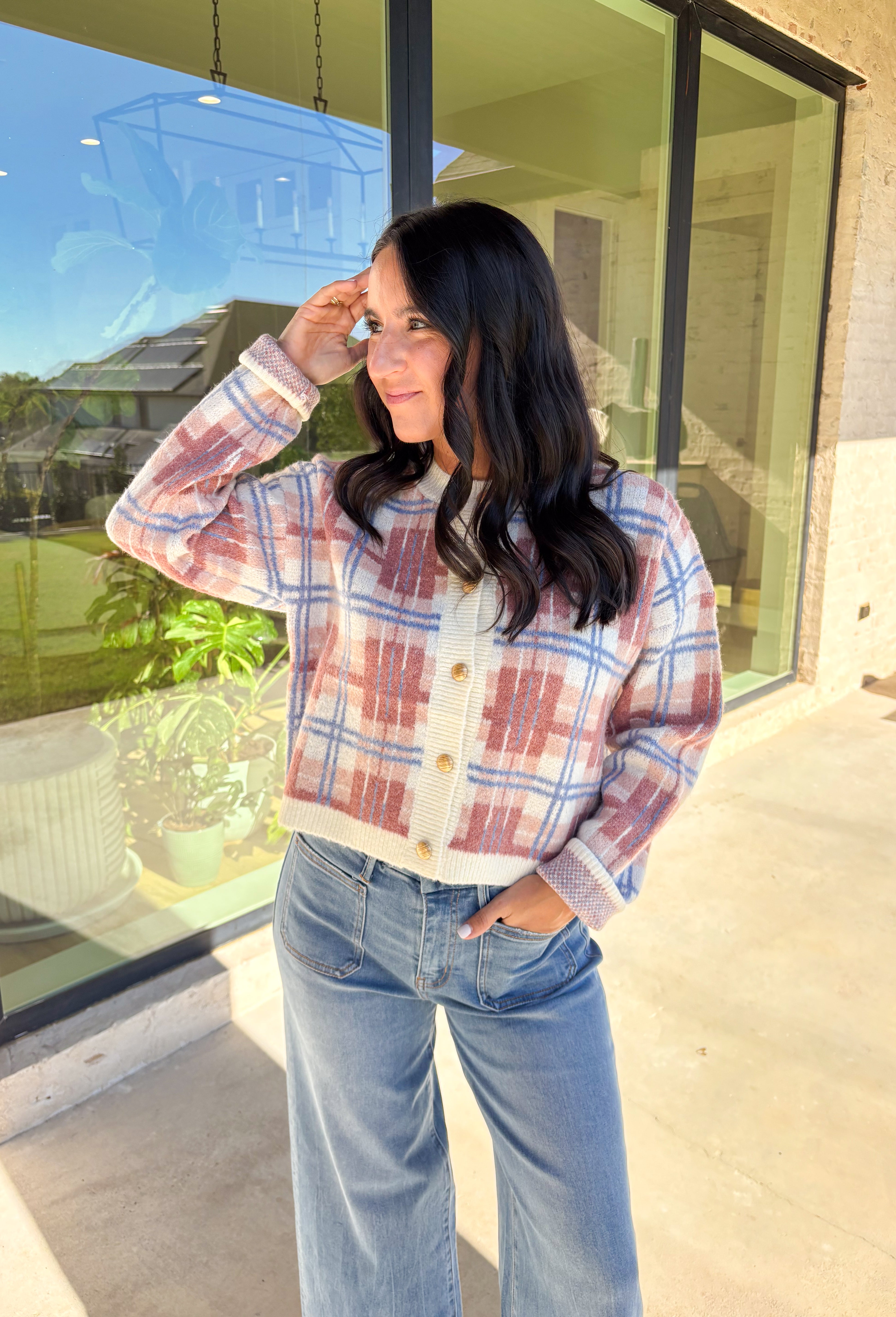 Plaid meets cozy charm in this cropped button-down cardigan. Designed in cream, blue, dark pink, and light pink, it’s the perfect pop of color for cooler days. Gold textured buttons add a polished detail, while the soft knit blend makes it extra comfortable. With its cropped fit and long sleeves, this cardigan is easy to style layered over a cami, tee, or even a dress for that just-right fall look.