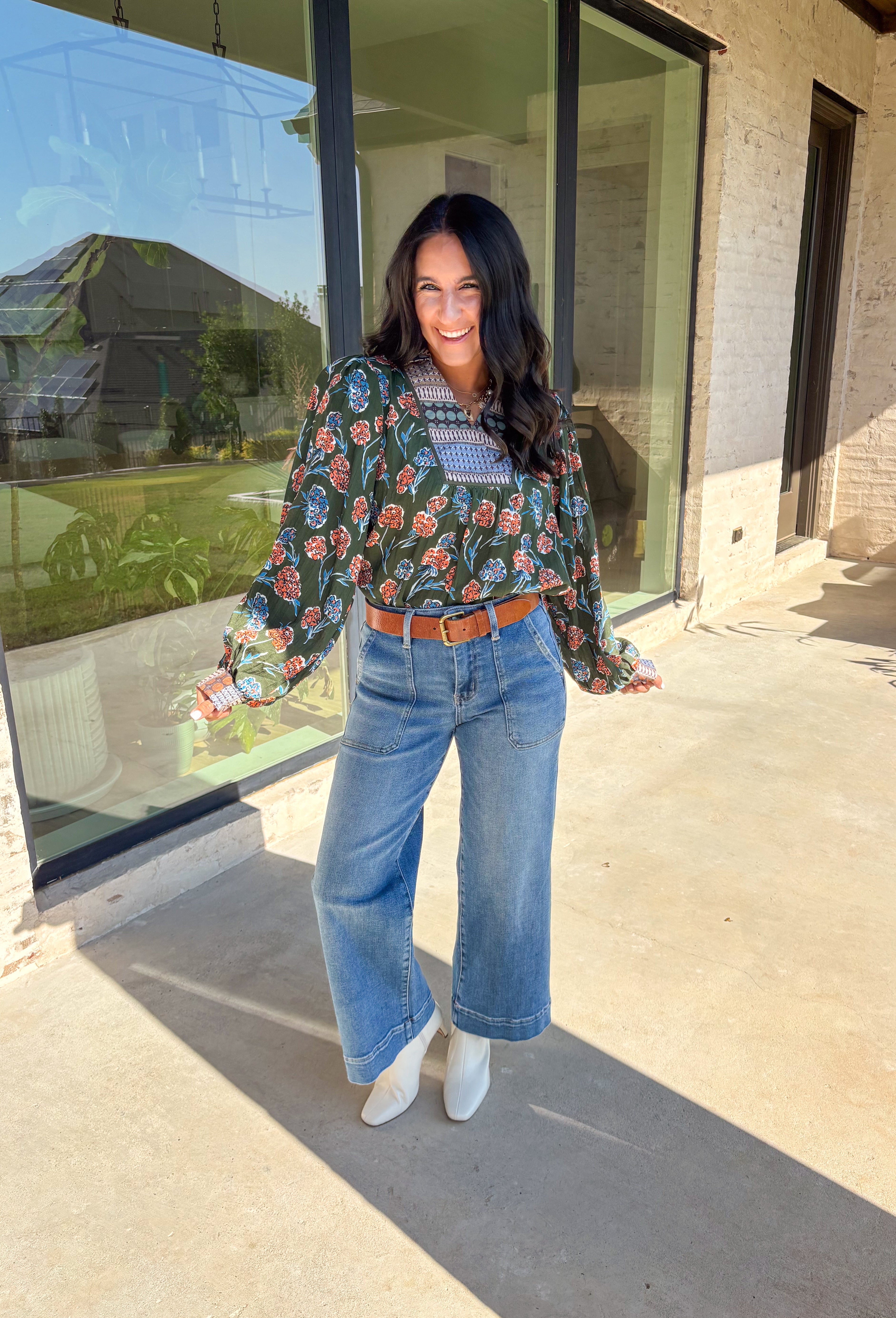 This green long sleeve top is a fresh mix of bold florals and thoughtful detail. Splashed with a colorful floral print in shades of orange, blue, black, and white, it’s balanced with a neutral abstract print along the front and collar for extra visual interest. Smocked sleeves finish the look with a feminine touch, making this blouse a statement piece you’ll love wearing through the season. Lightweight and easy to style, it’s perfect for everything from weekday wear to weekend outings.