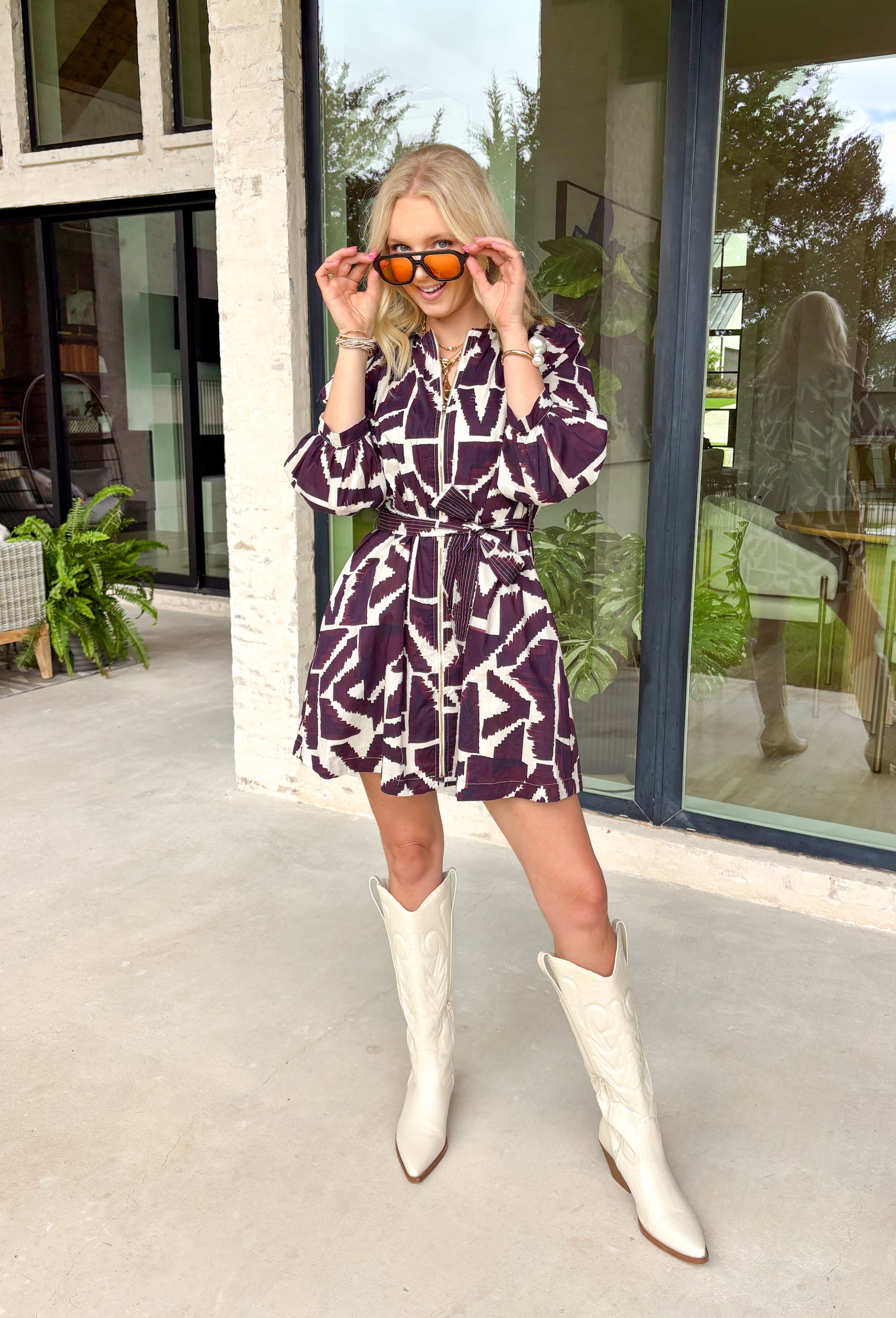 Make a bold yet feminine statement in this merlot and off-white geometric print mini dress by Entro. Designed with ¾ sleeves and a flattering self-tie waist belt, this dress balances comfort and style perfectly. The front zipper closure adds a modern touch, while the full lining keeps it easy and comfortable to wear. With its eye-catching pattern and rich fall tones, this dress is an effortless choice for any special occasion.