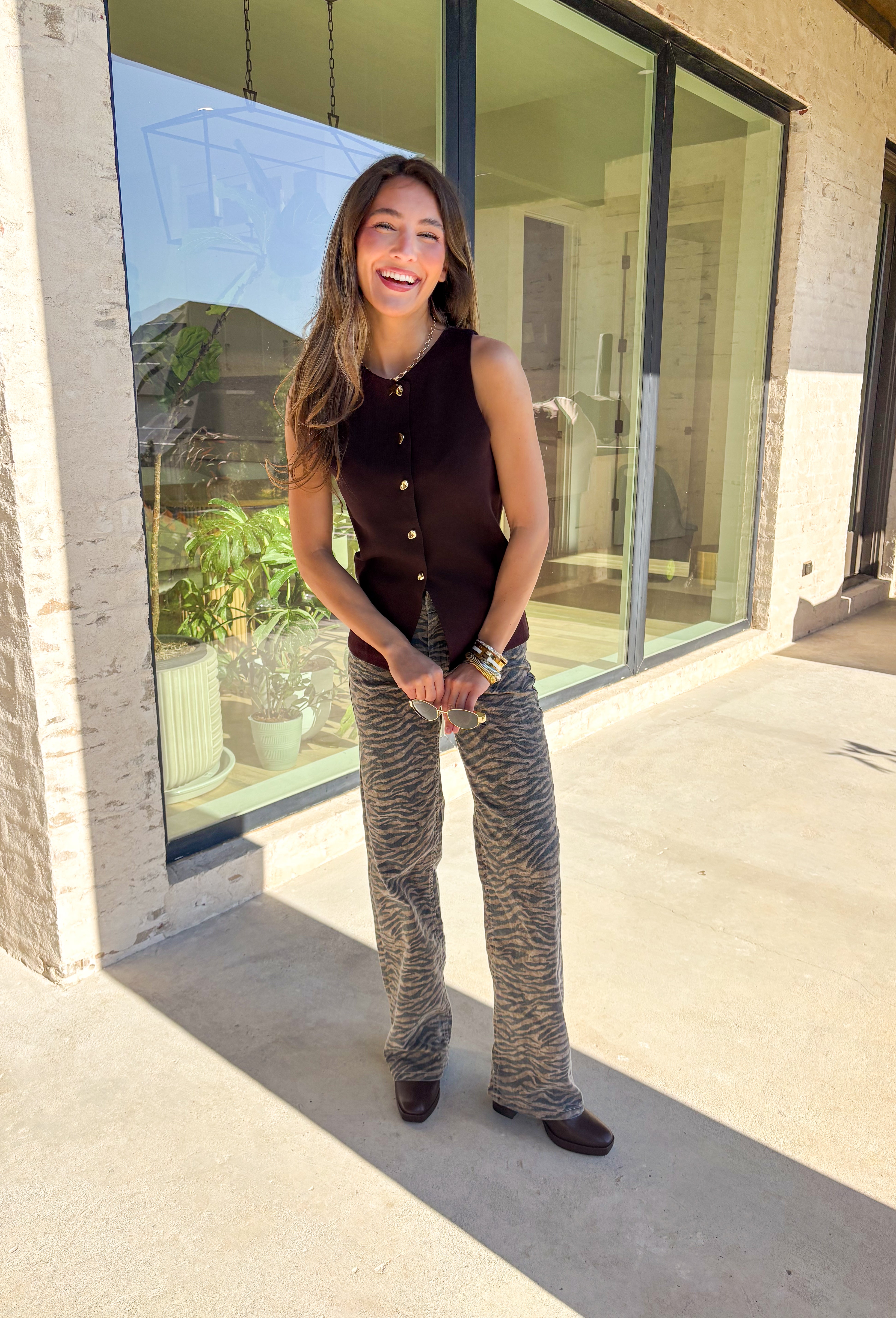 Classic meets modern in this sleeveless brown sweater by Iris. The button-down design is elevated with gold hammered buttons that add a chic, statement touch. Crafted in a soft knit with a lightweight feel, it’s perfect for layering under jackets or wearing solo on warmer days. A versatile piece that easily transitions from casual outings to dressier occasions.