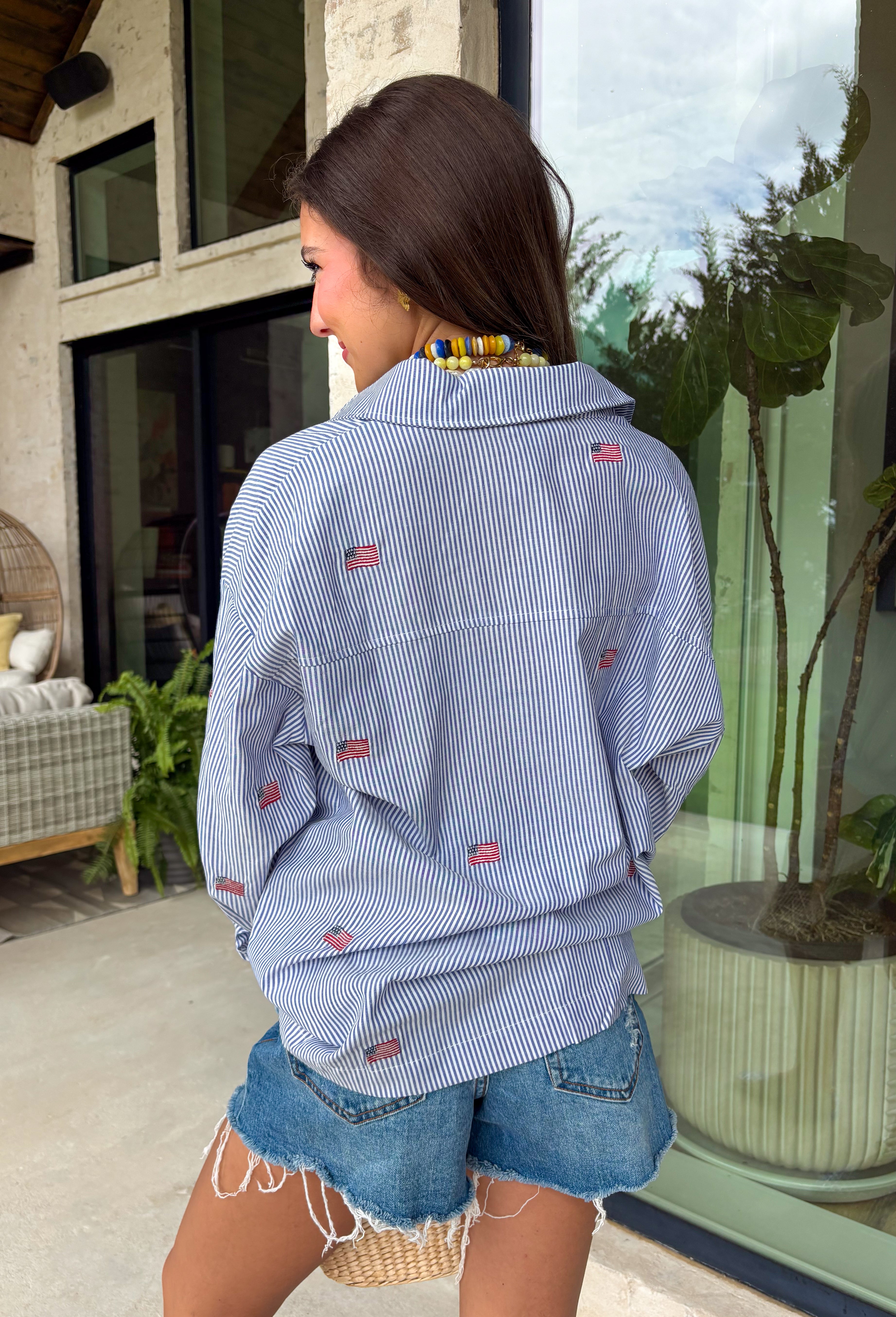 This blue and white stripe button down is the perfect blend of classic style and patriotic charm! Featuring embroidered American flags throughout, it adds a fun, festive touch while still feeling timeless and easy to wear. The collared neckline and button down design give it that effortless, polished look you can style for everything from backyard BBQs to fireworks and holiday weekends. Lightweight and breathable, it’s the perfect layer for all your summer celebrations. 