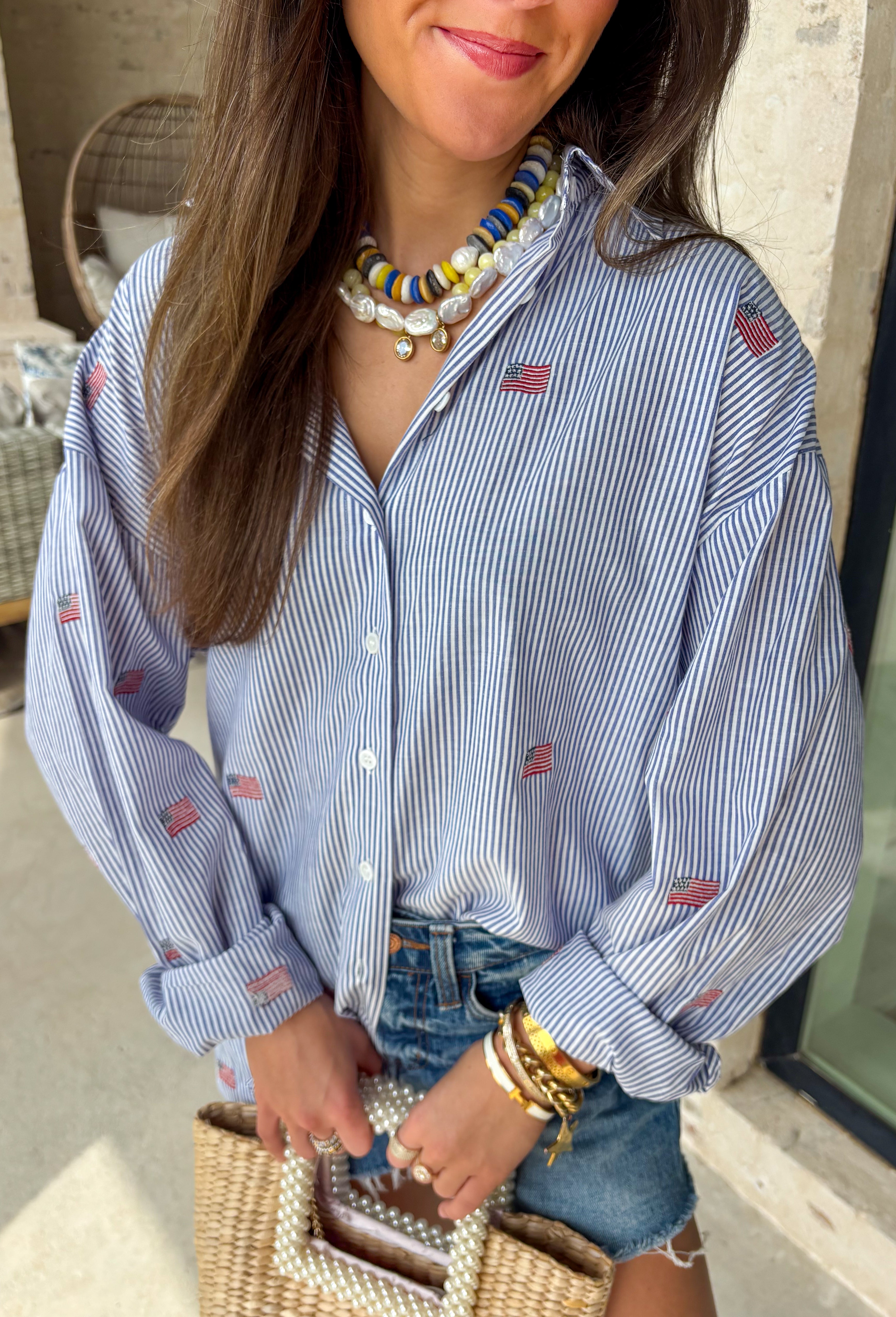 This blue and white stripe button down is the perfect blend of classic style and patriotic charm! Featuring embroidered American flags throughout, it adds a fun, festive touch while still feeling timeless and easy to wear. The collared neckline and button down design give it that effortless, polished look you can style for everything from backyard BBQs to fireworks and holiday weekends. Lightweight and breathable, it’s the perfect layer for all your summer celebrations. 