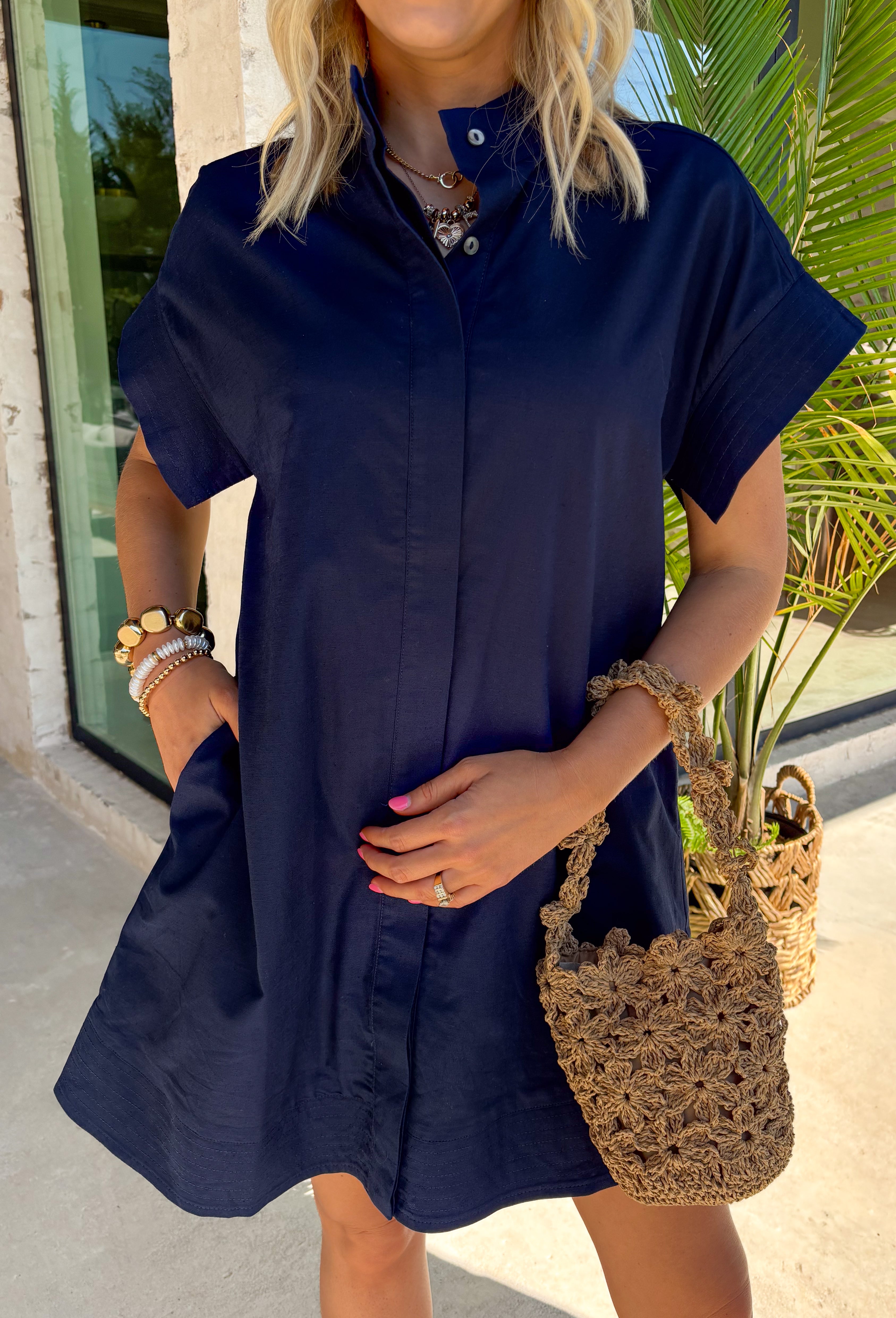 This navy short sleeve dress is the perfect, effortless piece your summer wardrobe needs! Made from a breathable cotton-linen blend, it’s lightweight and perfect for staying cool while still looking put together. The hidden button down design keeps the look clean and elevated, giving it that easy shirt dress feel you can dress up or down. Whether you're heading to lunch, work, or weekend plans, this dress brings the perfect pop of color. Just add sandals or sneakers and you’re set—don’t miss this one!