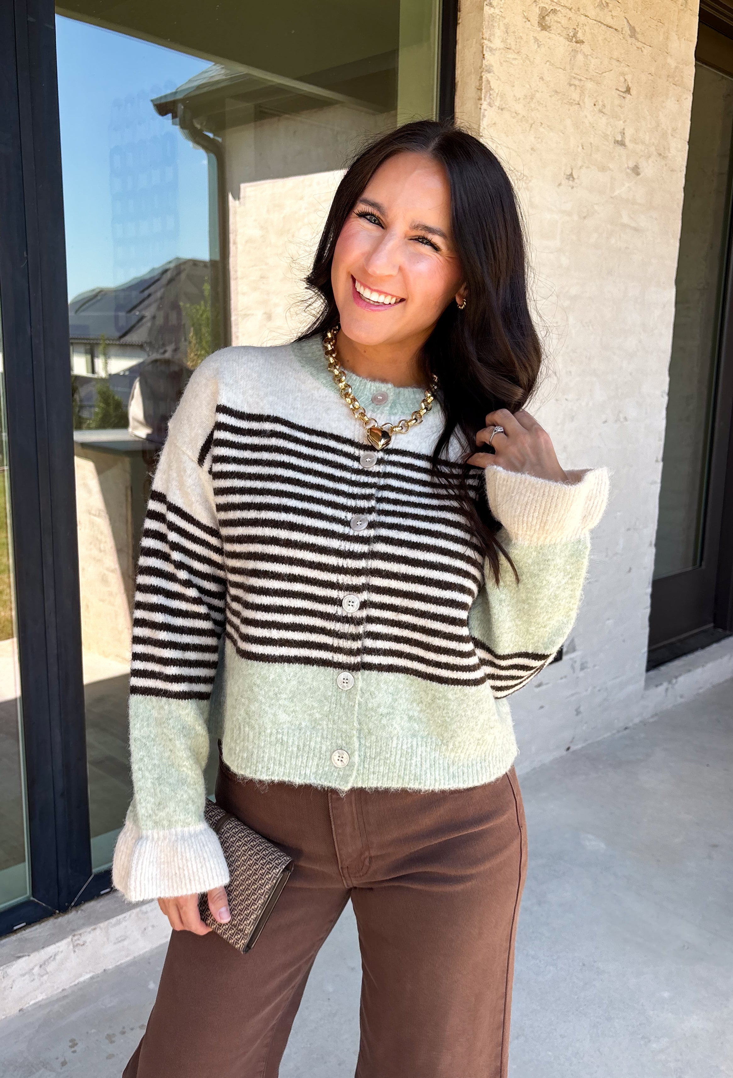 Wrap yourself in cozy comfort with this charming cardigan from Entro. Designed with a soft ecru knit and classic brown stripes, this timeless sweater gets a fresh pop of color from mint trim along the neckline, hem, and cuffs. The button-front design makes it easy to wear open over your favorite basics or buttoned up as a sweater, while the ultra-soft knit blend keeps you warm and comfortable all season long. 