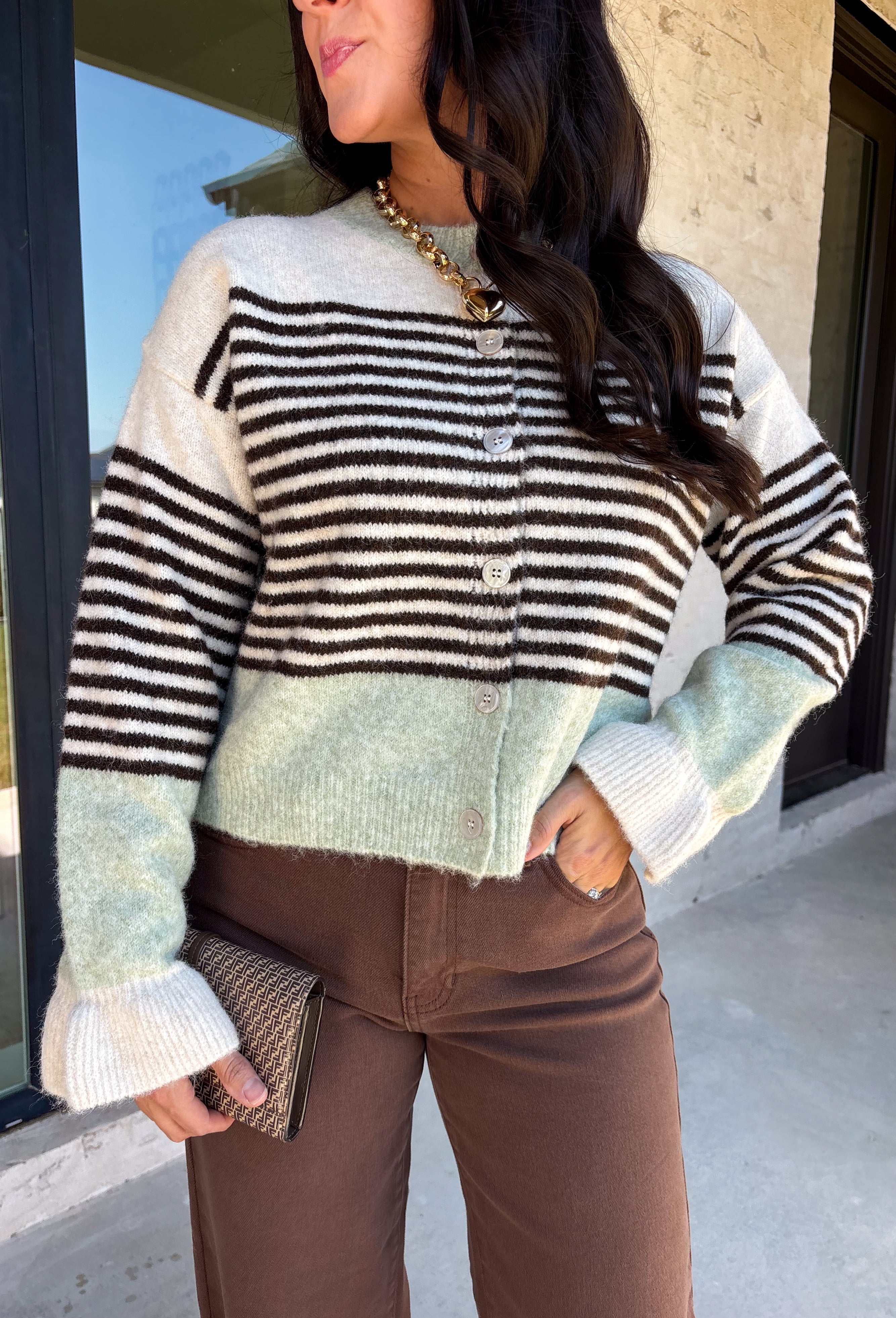 Wrap yourself in cozy comfort with this charming cardigan from Entro. Designed with a soft ecru knit and classic brown stripes, this timeless sweater gets a fresh pop of color from mint trim along the neckline, hem, and cuffs. The button-front design makes it easy to wear open over your favorite basics or buttoned up as a sweater, while the ultra-soft knit blend keeps you warm and comfortable all season long. 