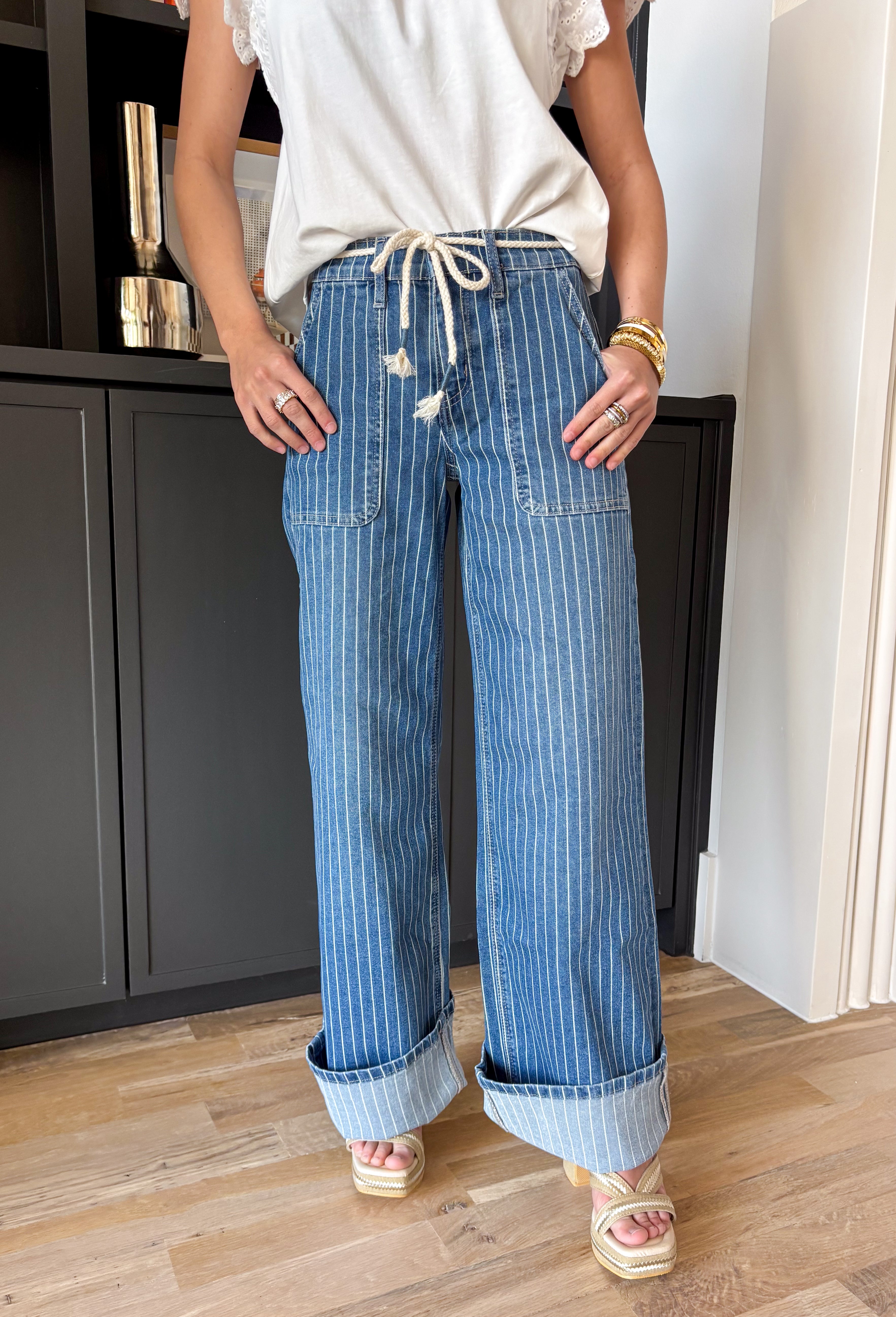 A little classic, a little fun — this medium wash wide leg jean by Lovervet is the perfect blend of polished and relaxed. The crisp white pinstripe print gives it that tailored feel, while the flowy wide leg silhouette keeps it effortlessly cool and on trend. Designed with a flattering high rise and a comfortable elastic back waistband, these jeans offer structure in the front with easy movement in the back. The removable self-tie detail lets you style it your way — cinched and feminine or clean and simple.