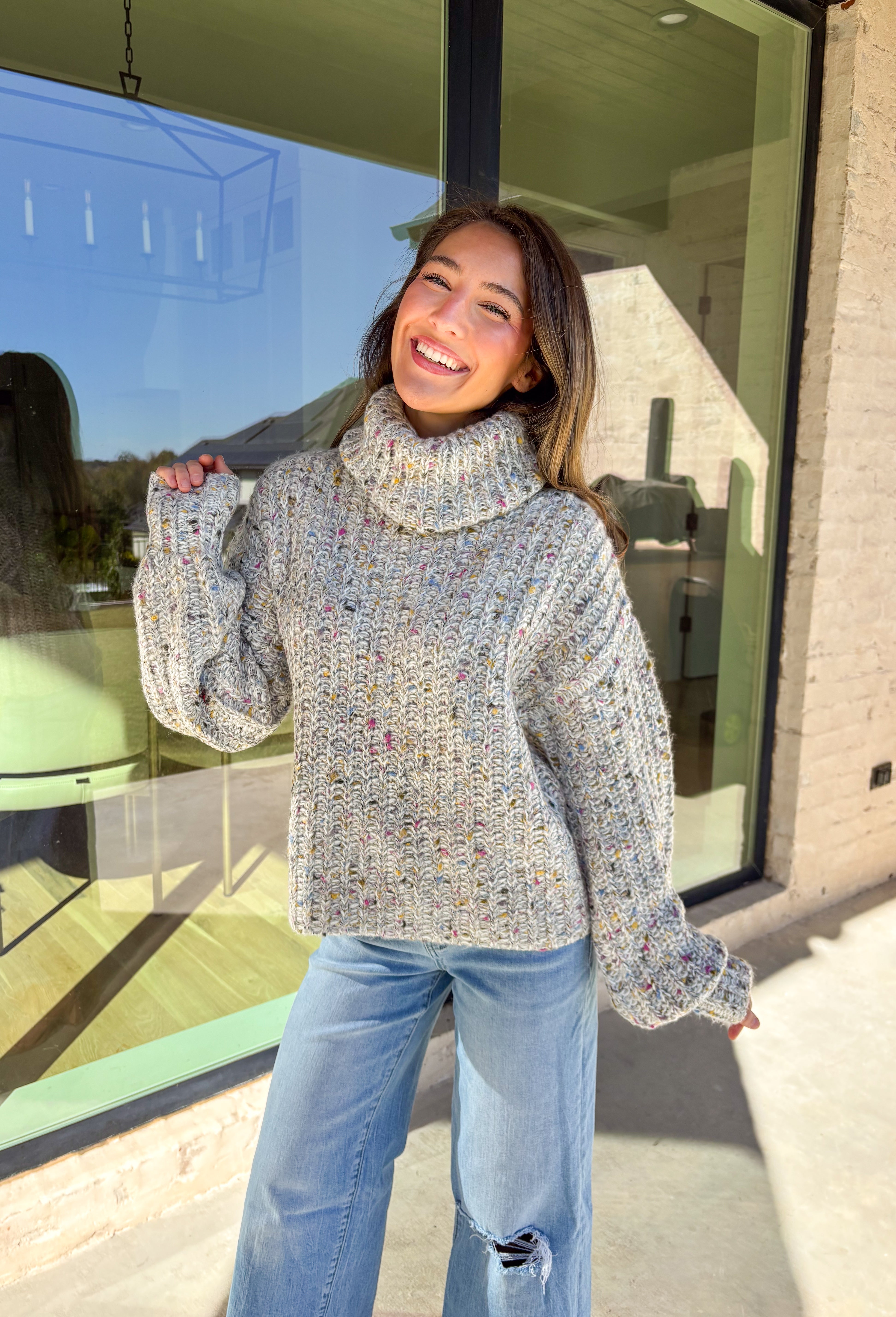 Stay warm and stylish this season in this neutral chunky knit turtleneck sweater by Mystree. Featuring colorful threading woven throughout, this cozy piece brings a playful pop to your winter wardrobe. The thick, soft knit and classic turtleneck design make it perfect for chilly days when you want to look cute and feel comfy.