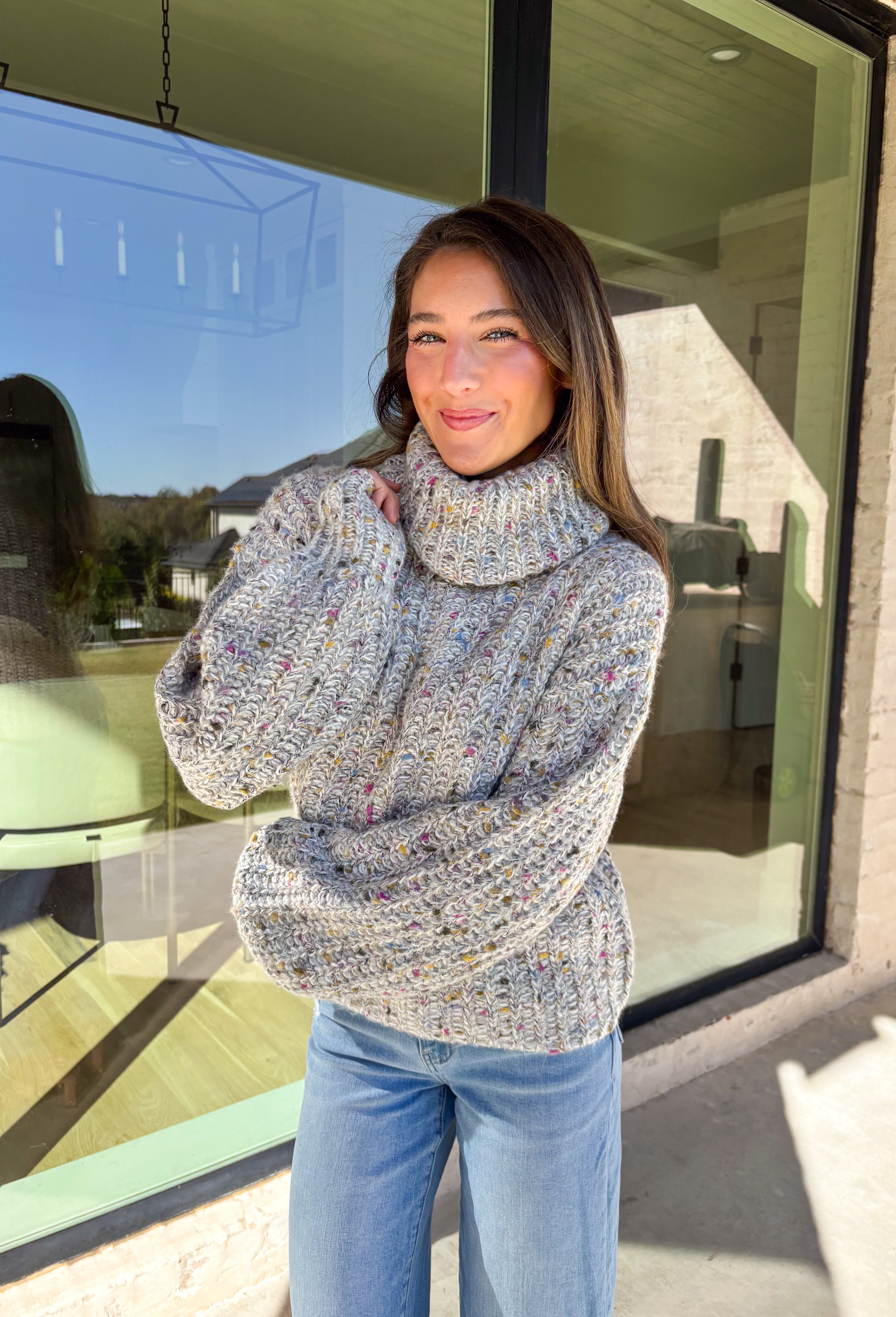 Stay warm and stylish this season in this neutral chunky knit turtleneck sweater by Mystree. Featuring colorful threading woven throughout, this cozy piece brings a playful pop to your winter wardrobe. The thick, soft knit and classic turtleneck design make it perfect for chilly days when you want to look cute and feel comfy.