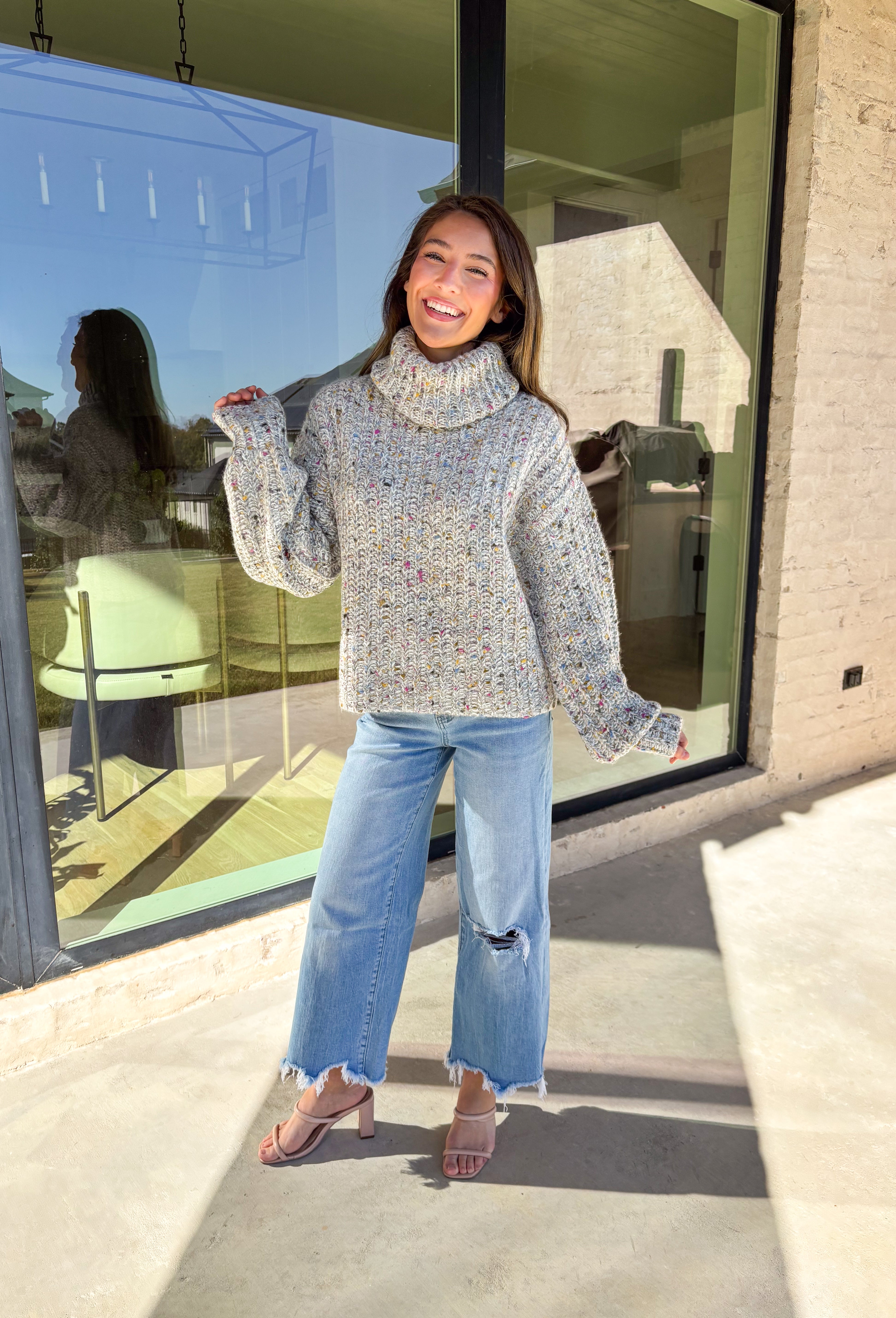 Stay warm and stylish this season in this neutral chunky knit turtleneck sweater by Mystree. Featuring colorful threading woven throughout, this cozy piece brings a playful pop to your winter wardrobe. The thick, soft knit and classic turtleneck design make it perfect for chilly days when you want to look cute and feel comfy.