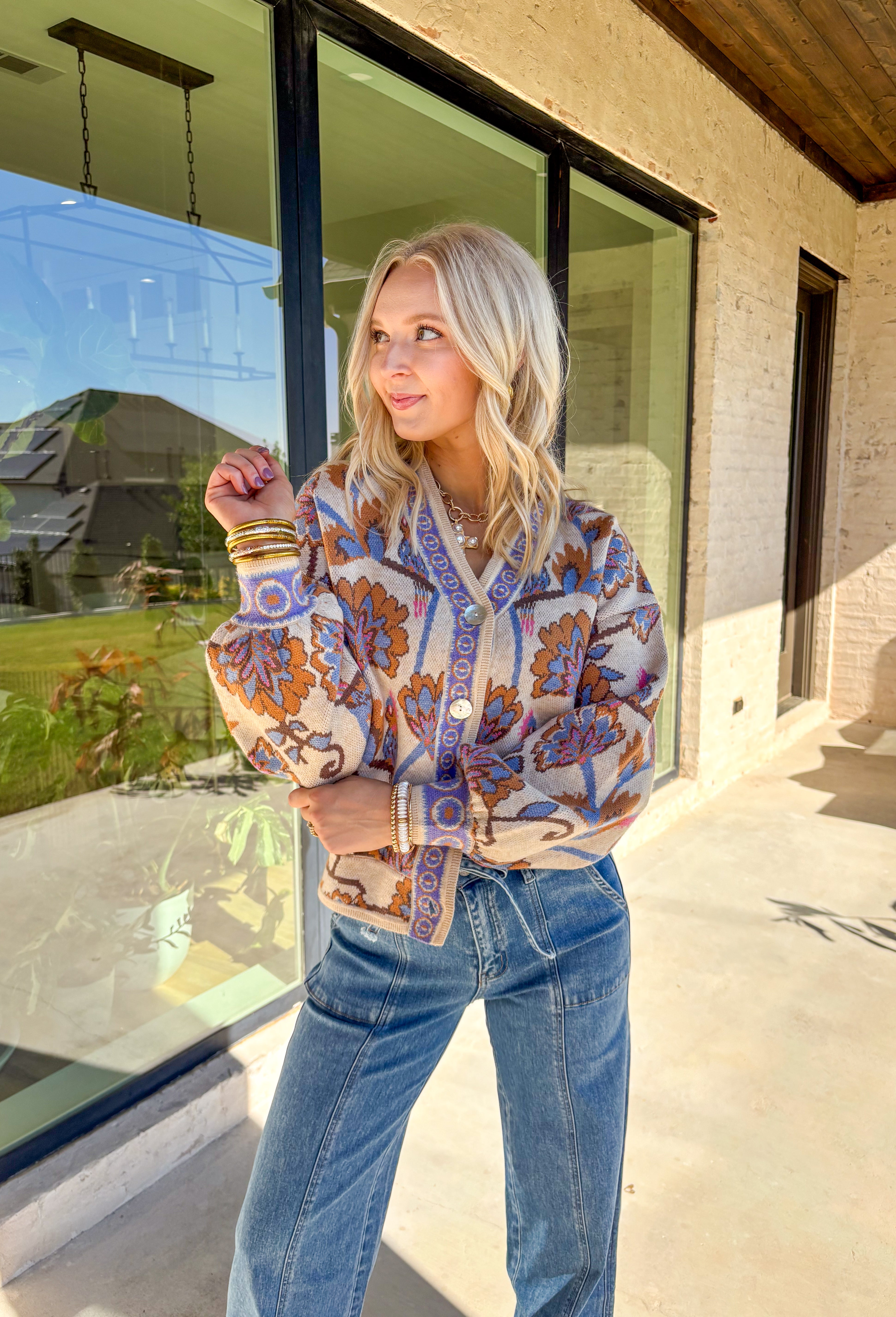 Cozy meets colorful in this tan button-down cardigan. Designed with a floral print in rich shades of periwinkle, purple, pink, and brown, it’s a warm layer that brings instant personality to your fall wardrobe. The long sleeves and soft knit blend keep it extra comfortable, while the button-front closure makes it easy to wear open or closed. Perfect for layering with denim, skirts, or dresses, this cardigan is as versatile as it is charming.