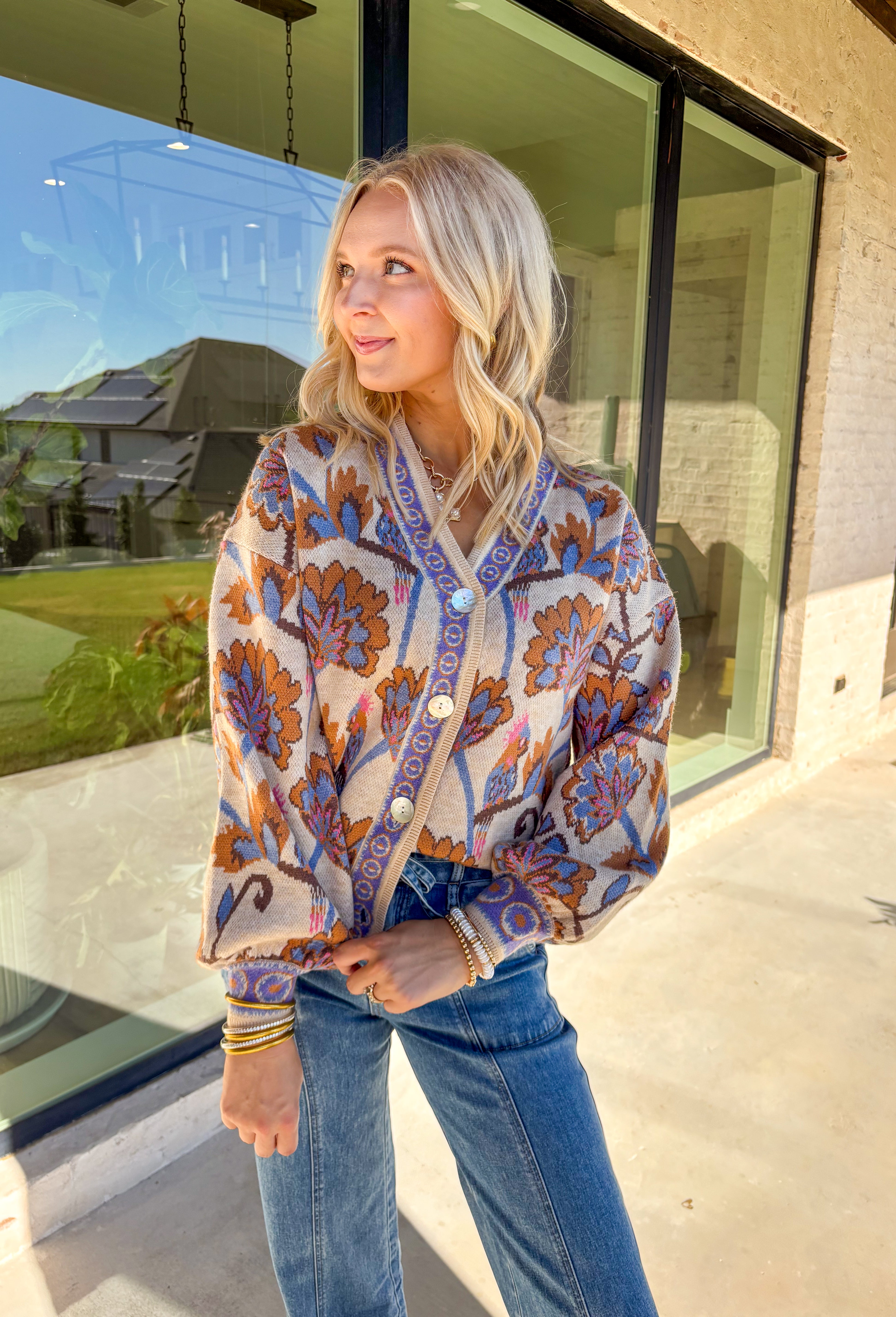 Cozy meets colorful in this tan button-down cardigan. Designed with a floral print in rich shades of periwinkle, purple, pink, and brown, it’s a warm layer that brings instant personality to your fall wardrobe. The long sleeves and soft knit blend keep it extra comfortable, while the button-front closure makes it easy to wear open or closed. Perfect for layering with denim, skirts, or dresses, this cardigan is as versatile as it is charming.