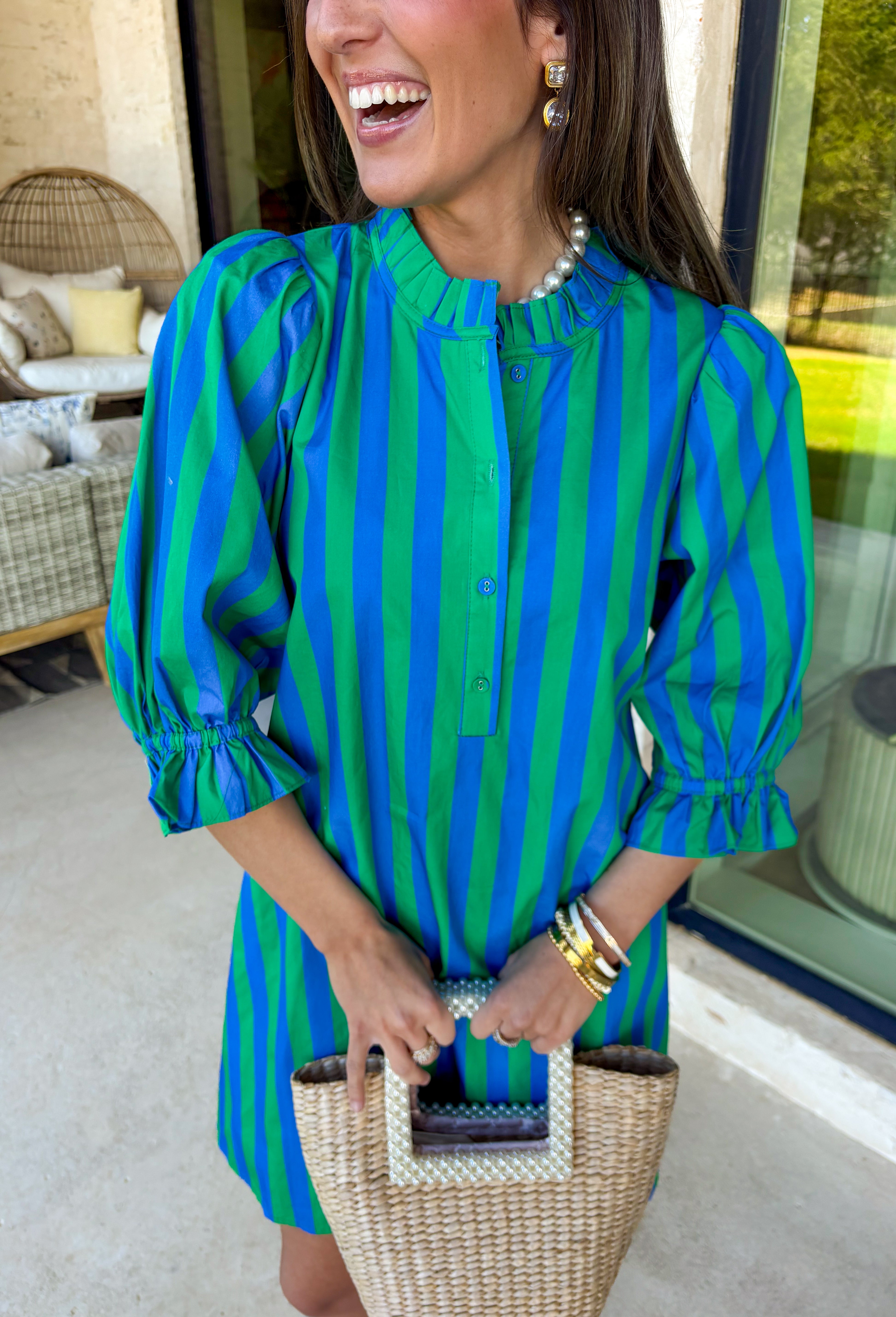 Fresh stripes and easy details make this green and blue dress by Entro a spring must-have. Designed with a striped pattern, it features ¾ length puff sleeves that add a playful, feminine touch. The ruffled band collar and partial button-front closure give it a polished feel, while the self-tie at the back waist creates a flattering, adjustable fit. Fully lined for comfort, this dress is perfect for spring days when you want something effortless, cute, and ready to go.