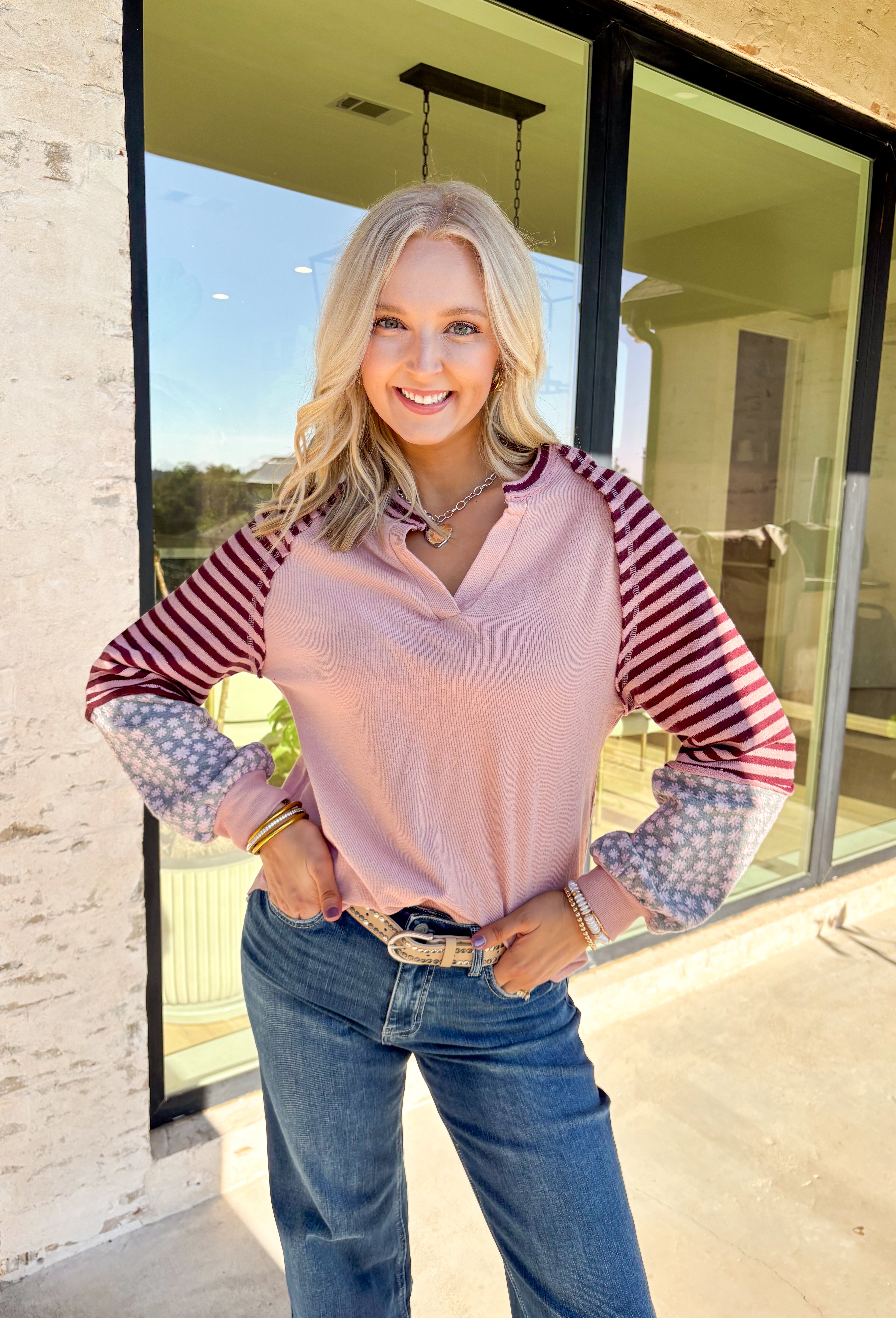 This blush long sleeve top by New In is a playful mix of prints and cozy comfort. The split neckline keeps the silhouette casual, while the sleeves bring in unexpected detail with burgundy stripes paired against gray and pink florals. Made from 100% cotton, it’s lightweight, breathable, and perfect for easy layering through the season.