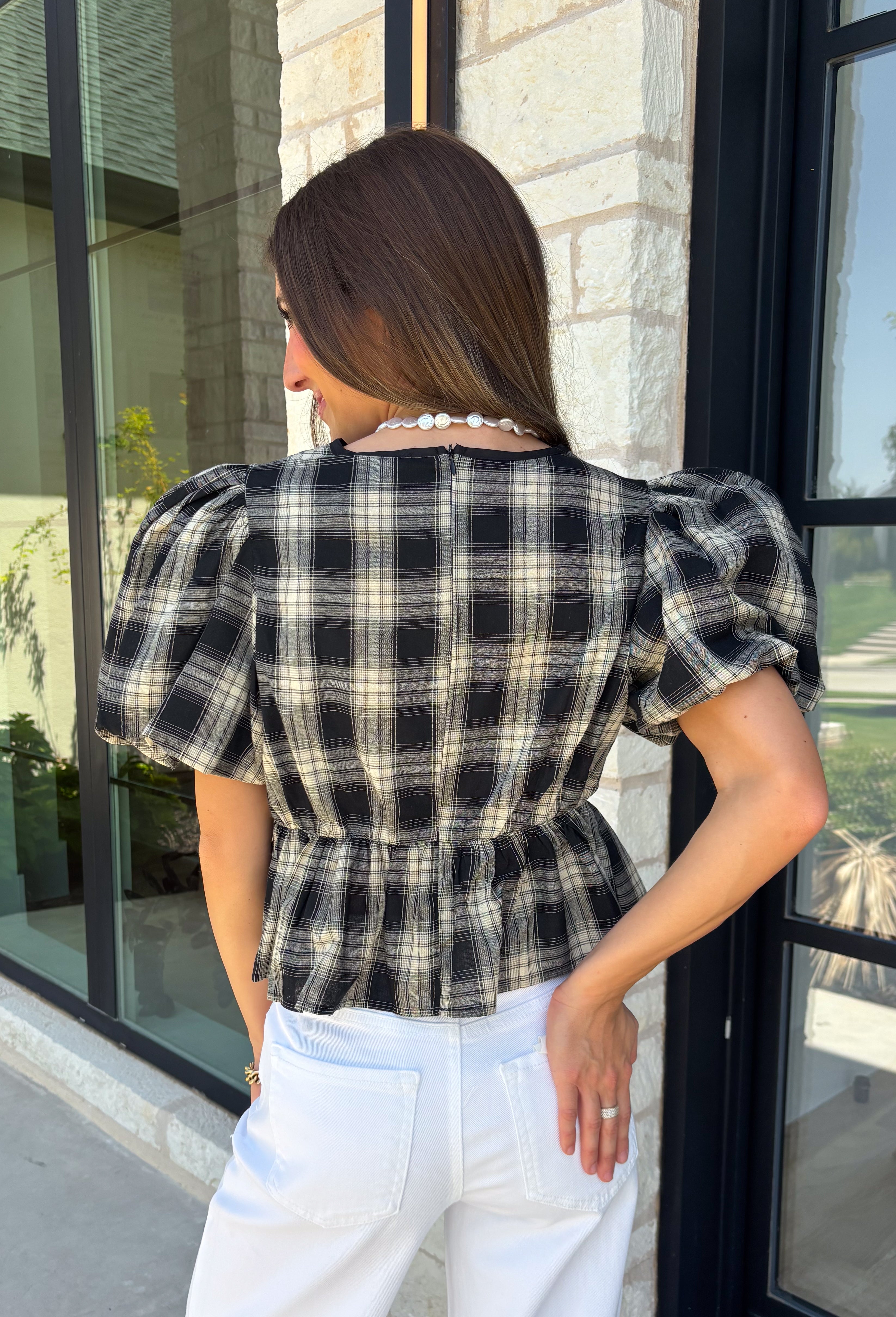 Nothing says fall quite like classic plaid! This black and tan plaid top brings timeless autumn style with a flattering structured babydoll silhouette that's easy to dress up or down. Feminine puff sleeves add a charming touch, while the back zipper closure creates a polished fit. Crafted from a breathable cotton blend, it's the perfect top for everything from pumpkin patch adventures and weekend brunches to casual office days and family gatherings.