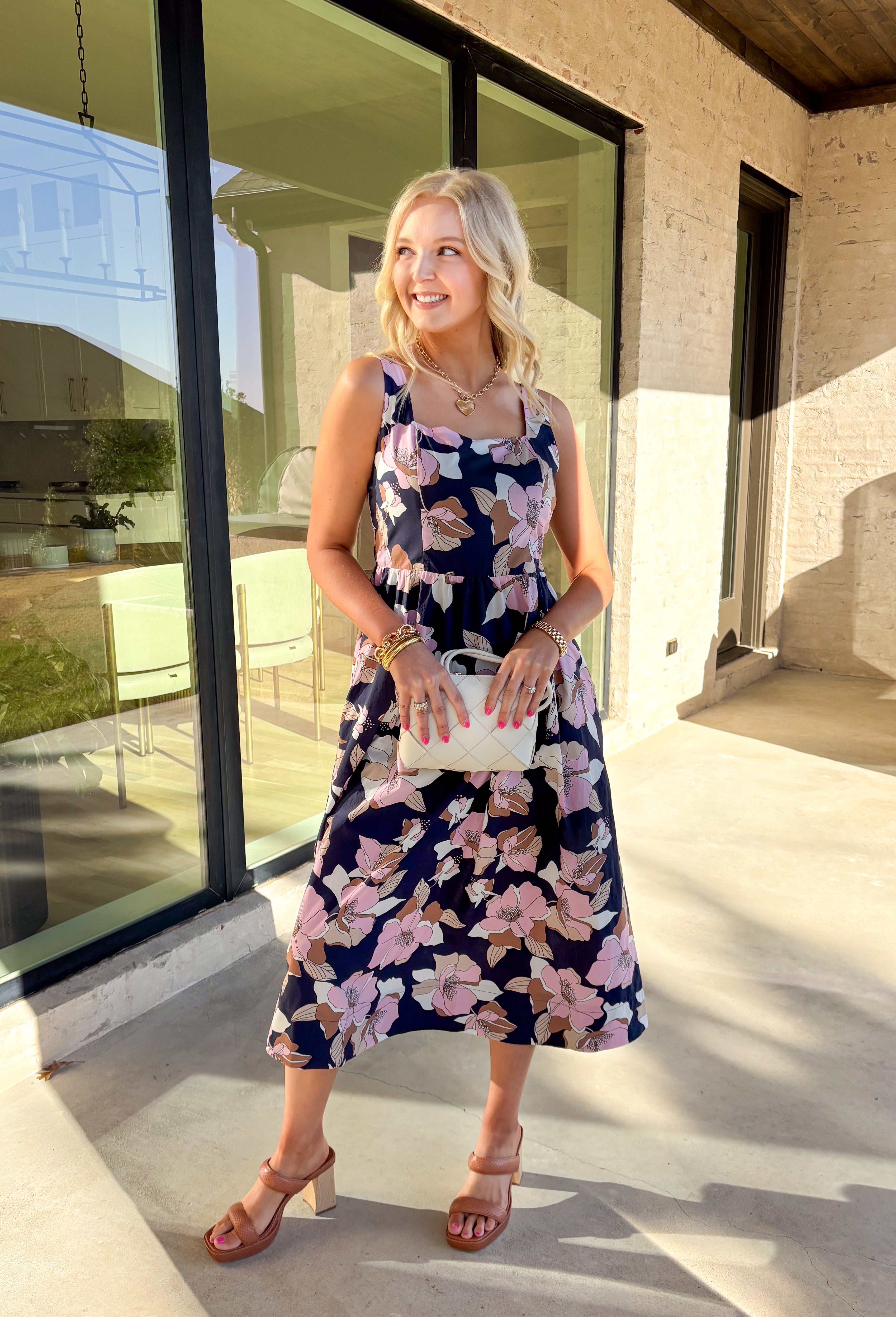 Step into effortless charm with this navy midi dress, blooming with a colorful floral print. Designed with a flattering square neckline and adjustable straps at the back, this pullover dress offers both comfort and style. The smocked back panel ensures a perfect fit, while the side pockets add a functional touch. Fully lined and crafted from breathable 100% cotton, this dress is perfect for sunny days, brunch dates, or a weekend getaway.