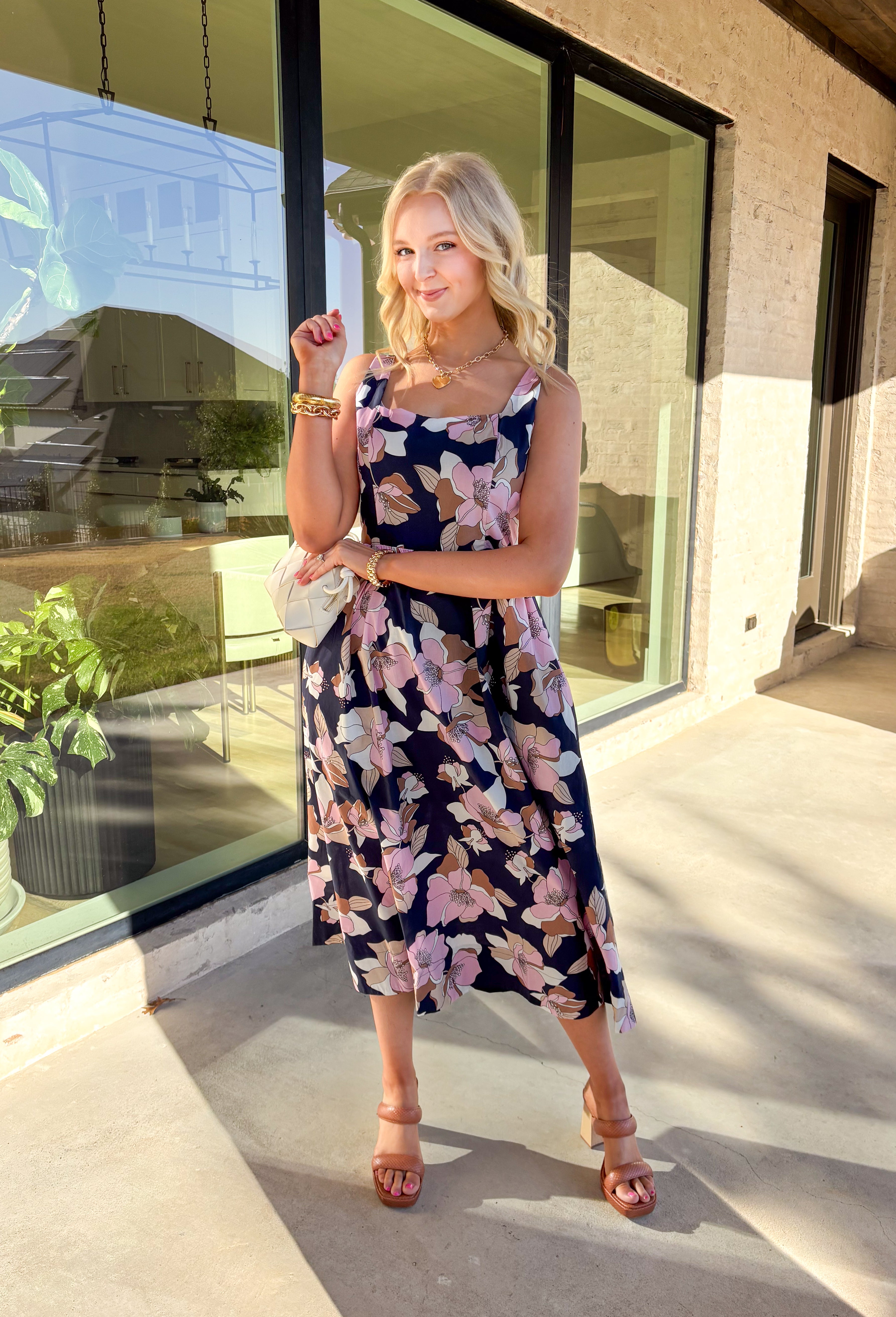 Step into effortless charm with this navy midi dress, blooming with a colorful floral print. Designed with a flattering square neckline and adjustable straps at the back, this pullover dress offers both comfort and style. The smocked back panel ensures a perfect fit, while the side pockets add a functional touch. Fully lined and crafted from breathable 100% cotton, this dress is perfect for sunny days, brunch dates, or a weekend getaway.