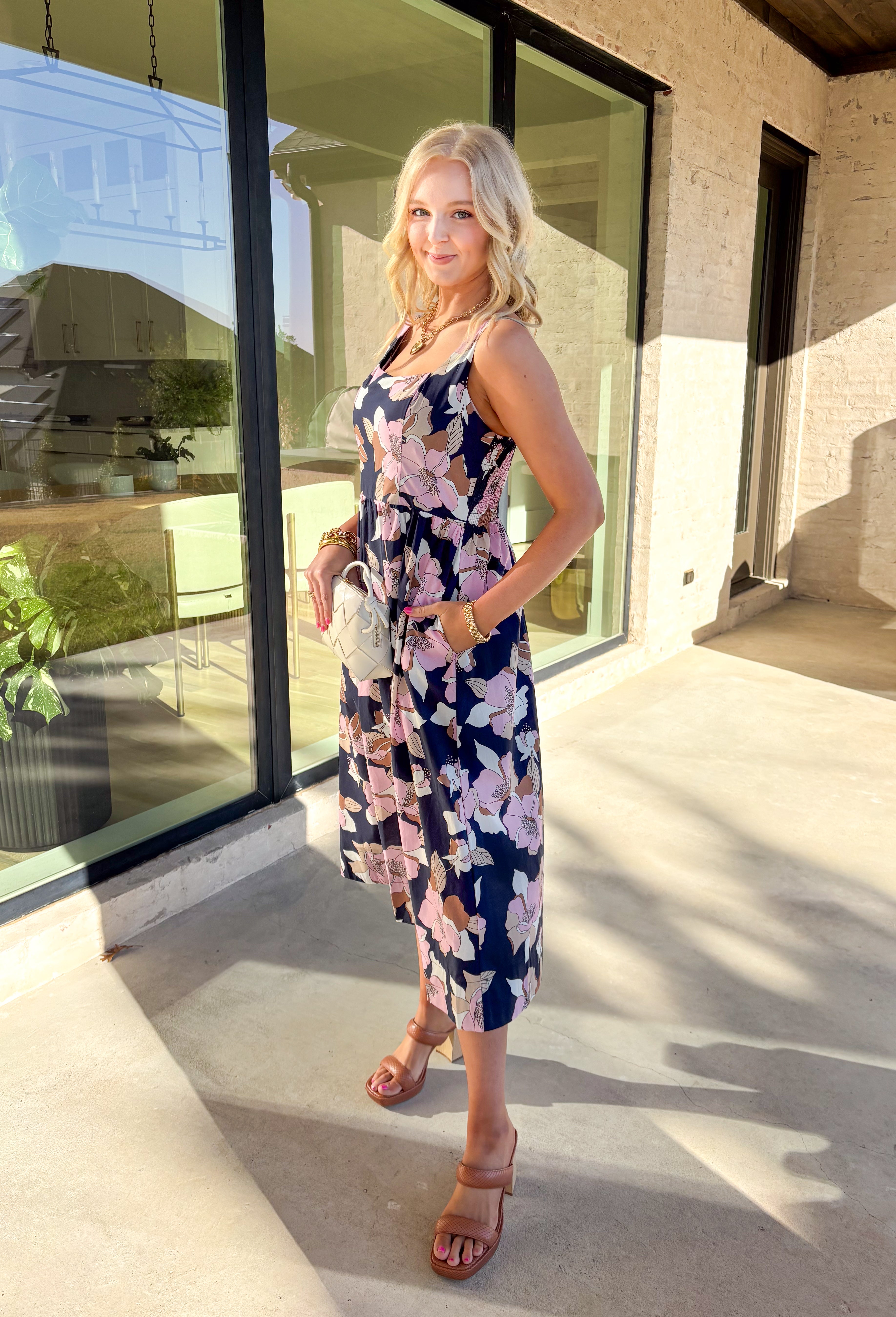 Step into effortless charm with this navy midi dress, blooming with a colorful floral print. Designed with a flattering square neckline and adjustable straps at the back, this pullover dress offers both comfort and style. The smocked back panel ensures a perfect fit, while the side pockets add a functional touch. Fully lined and crafted from breathable 100% cotton, this dress is perfect for sunny days, brunch dates, or a weekend getaway.