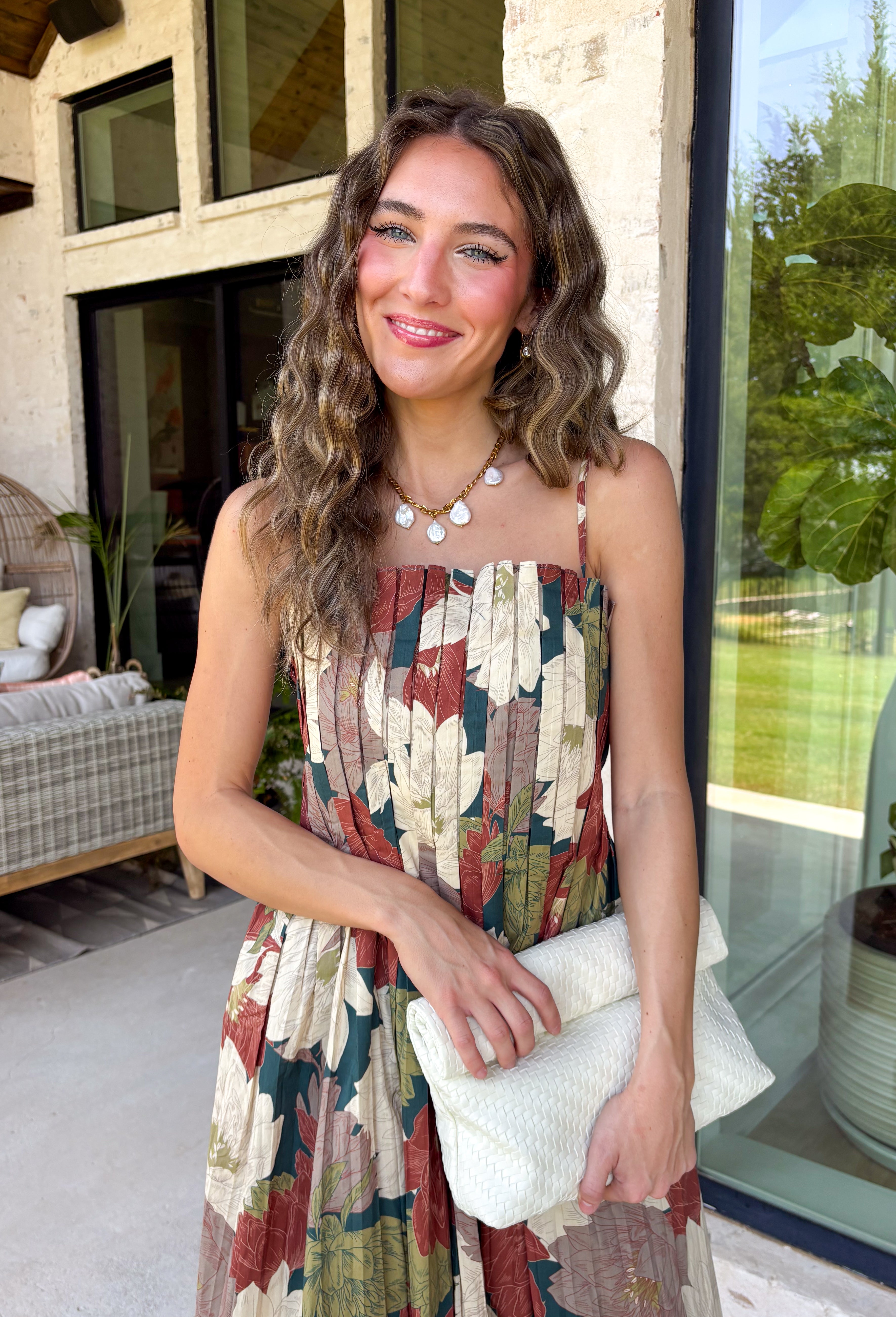 Beautifully feminine and full of rich seasonal color, this floral midi dress is a timeless addition to your fall wardrobe. Designed in a stunning dark teal hue with a gorgeous floral print in warm autumn shades, this dress is perfect for everything from family photos to holiday gatherings. The straight neckline and pleated bodice create an elegant, flattering silhouette, while the adjustable straps and smocked back provide a comfortable, customizable fit. 