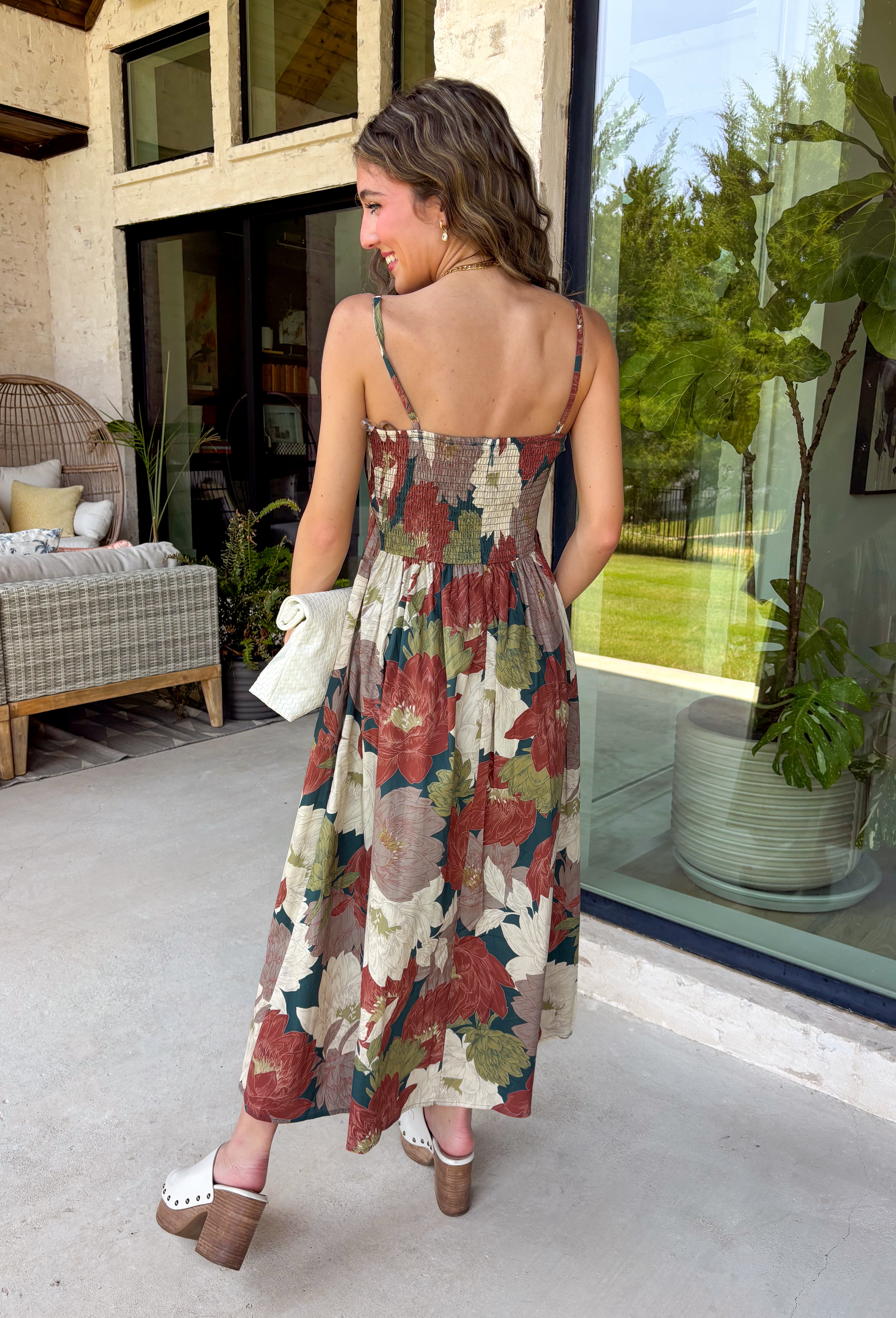 Beautifully feminine and full of rich seasonal color, this floral midi dress is a timeless addition to your fall wardrobe. Designed in a stunning dark teal hue with a gorgeous floral print in warm autumn shades, this dress is perfect for everything from family photos to holiday gatherings. The straight neckline and pleated bodice create an elegant, flattering silhouette, while the adjustable straps and smocked back provide a comfortable, customizable fit. 