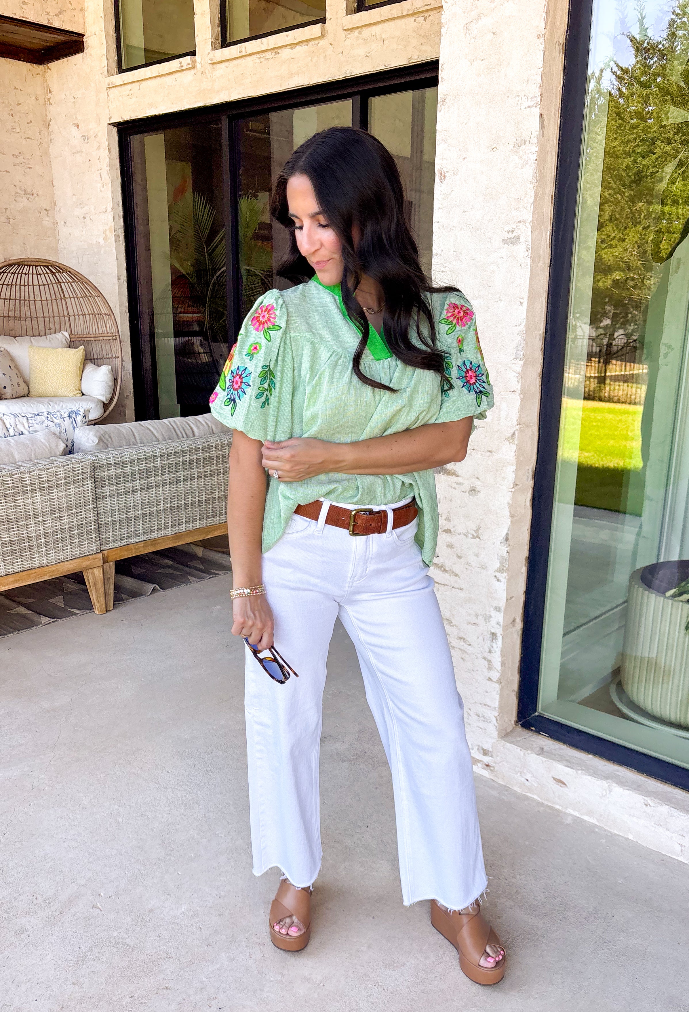 This light green short sleeve top is a true spring standout with its cheerful mix of color and texture. The puff sleeves steal the show with vibrant embroidered details in pink, red, blue, yellow, and green, adding a playful, handcrafted feel that instantly elevates your look. A brighter green contrast trim at the neckline gives it a fresh pop that frames the face beautifully. Lightweight and easy to wear, this top is perfect for bringing a little extra color and personality to your everyday spring outfits.