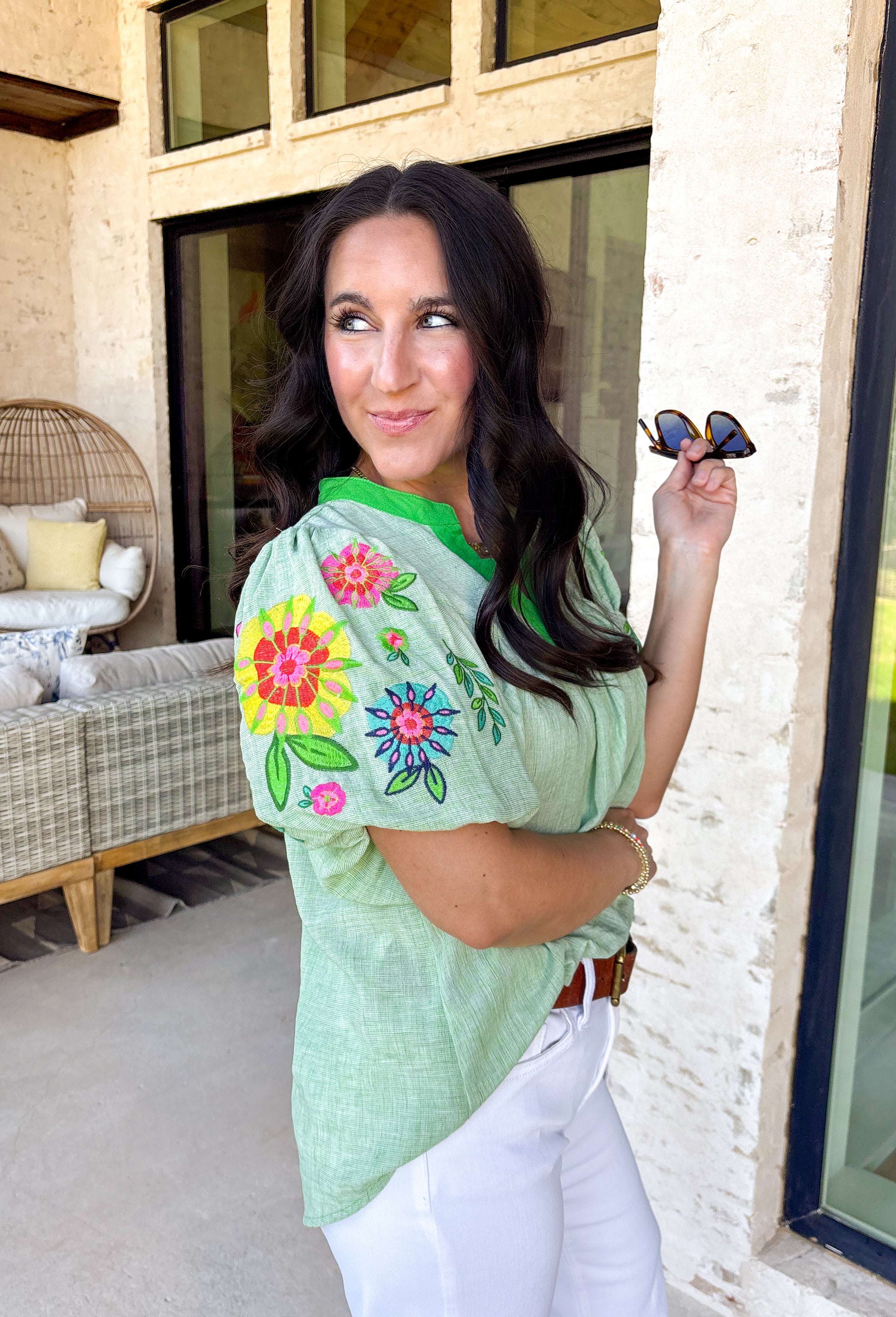 This light green short sleeve top is a true spring standout with its cheerful mix of color and texture. The puff sleeves steal the show with vibrant embroidered details in pink, red, blue, yellow, and green, adding a playful, handcrafted feel that instantly elevates your look. A brighter green contrast trim at the neckline gives it a fresh pop that frames the face beautifully. Lightweight and easy to wear, this top is perfect for bringing a little extra color and personality to your everyday spring outfits.